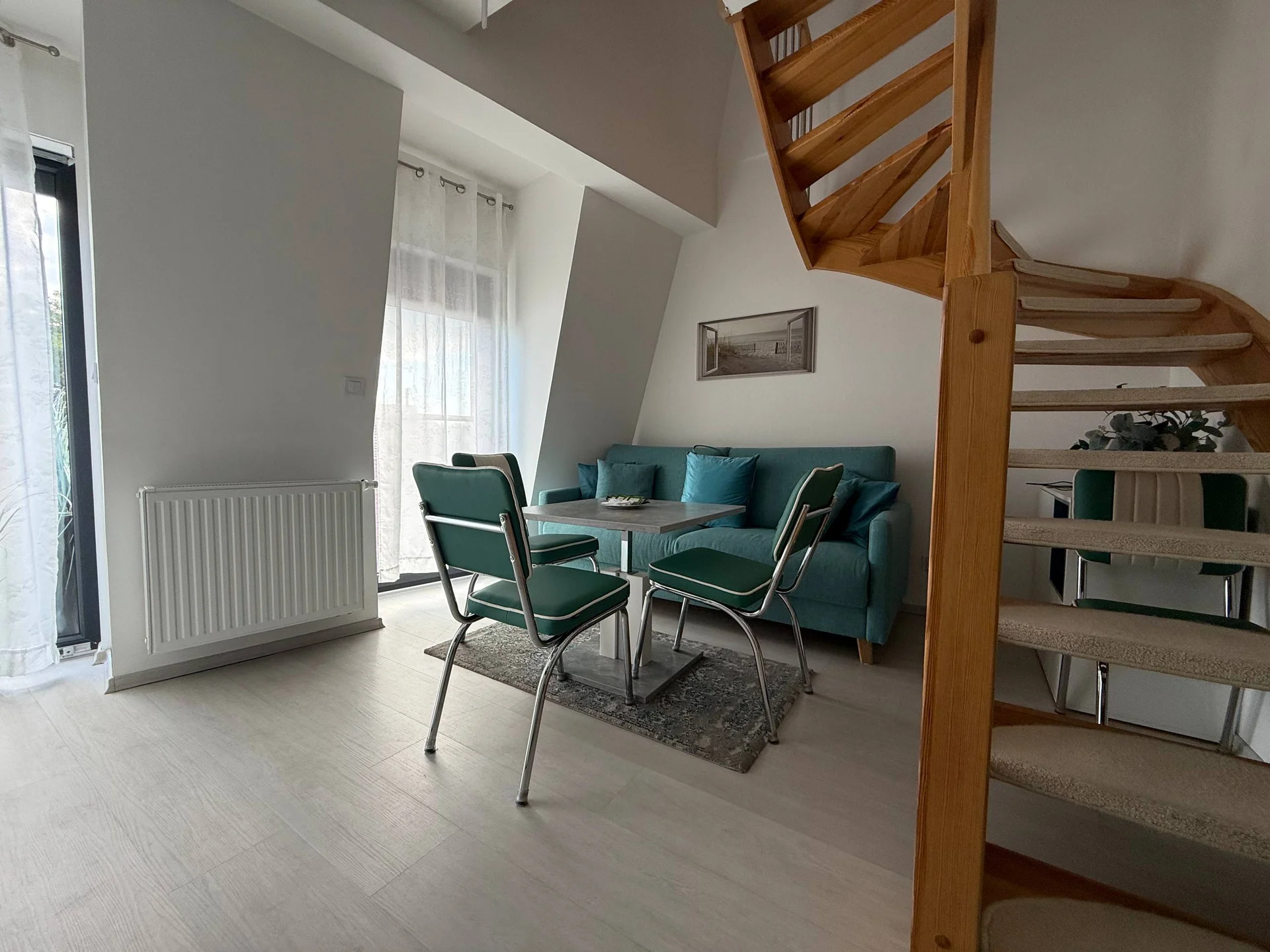 A living room with a modern design and wooden staircase.