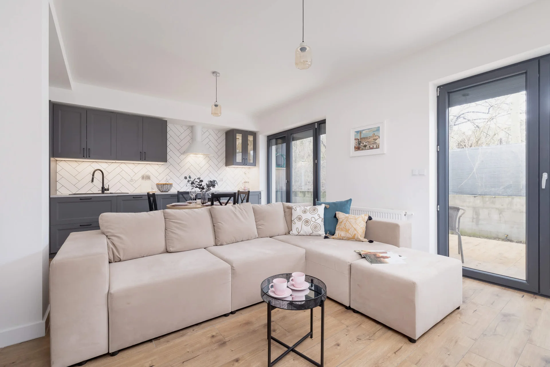 A spacious and modern living room with neutral-toned furniture, a large L-shaped sofa, and a sleek coffee table, creating a cozy yet stylish atmosphere.