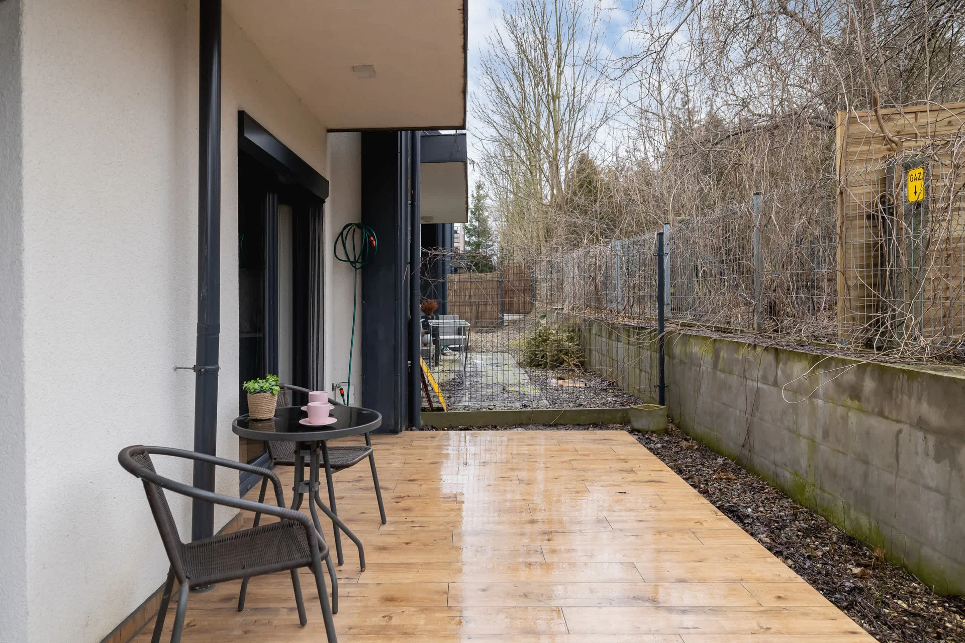 A private patio area with outdoor seating, surrounded by greenery, perfect for enjoying the fresh air in a peaceful setting.
