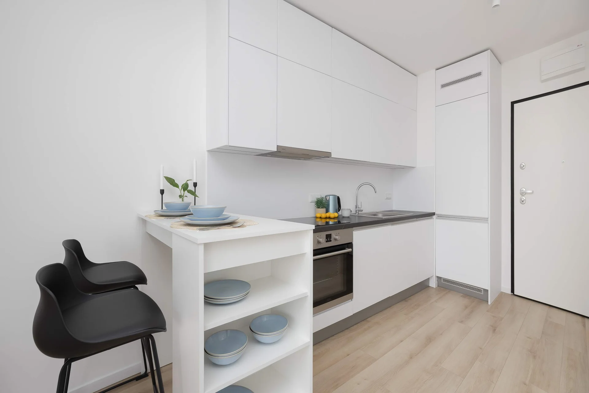 Modern kitchenette with white cabinets and dining area