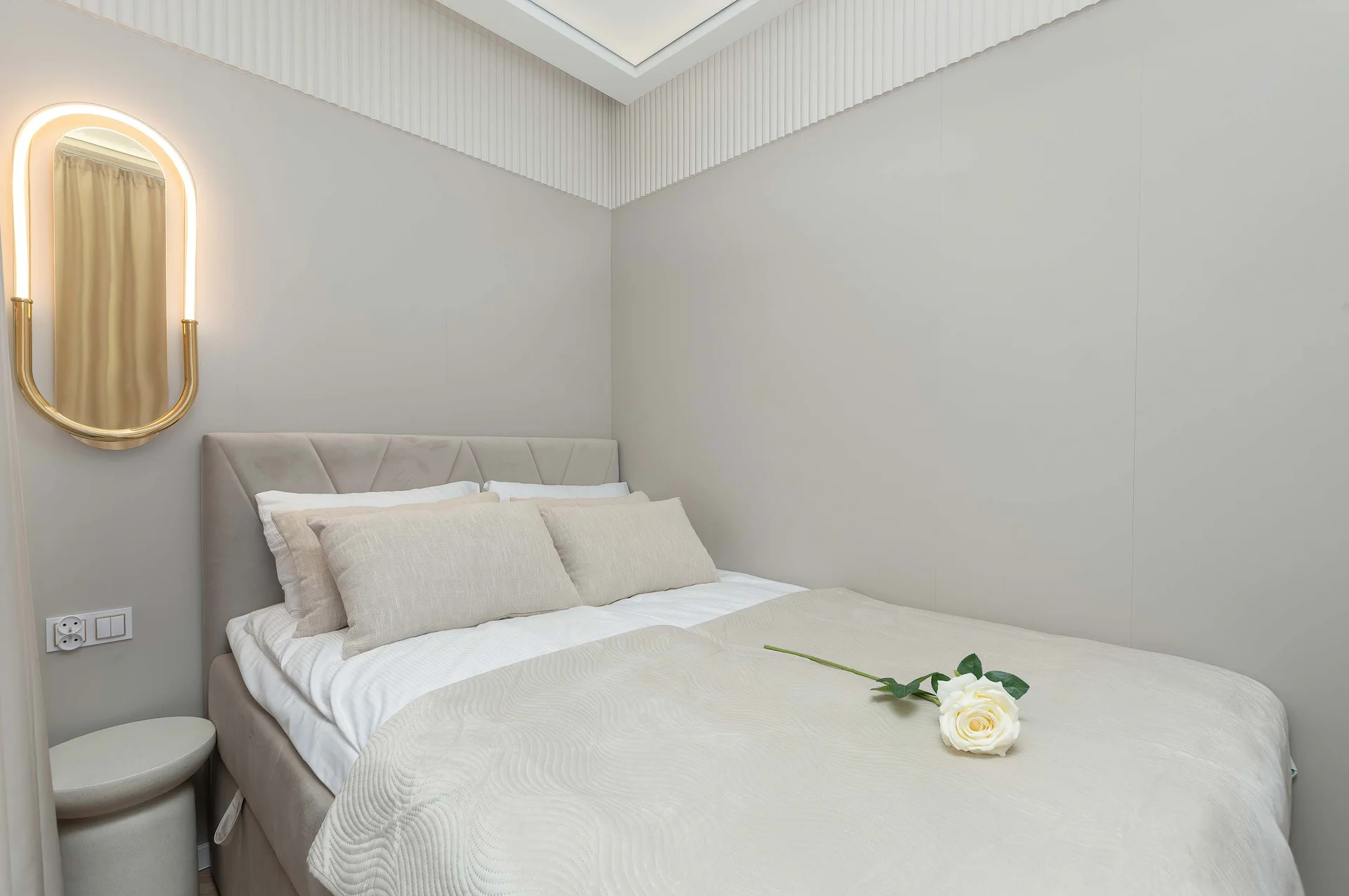 Cozy sleeping area with upholstered bed and modern wall lighting