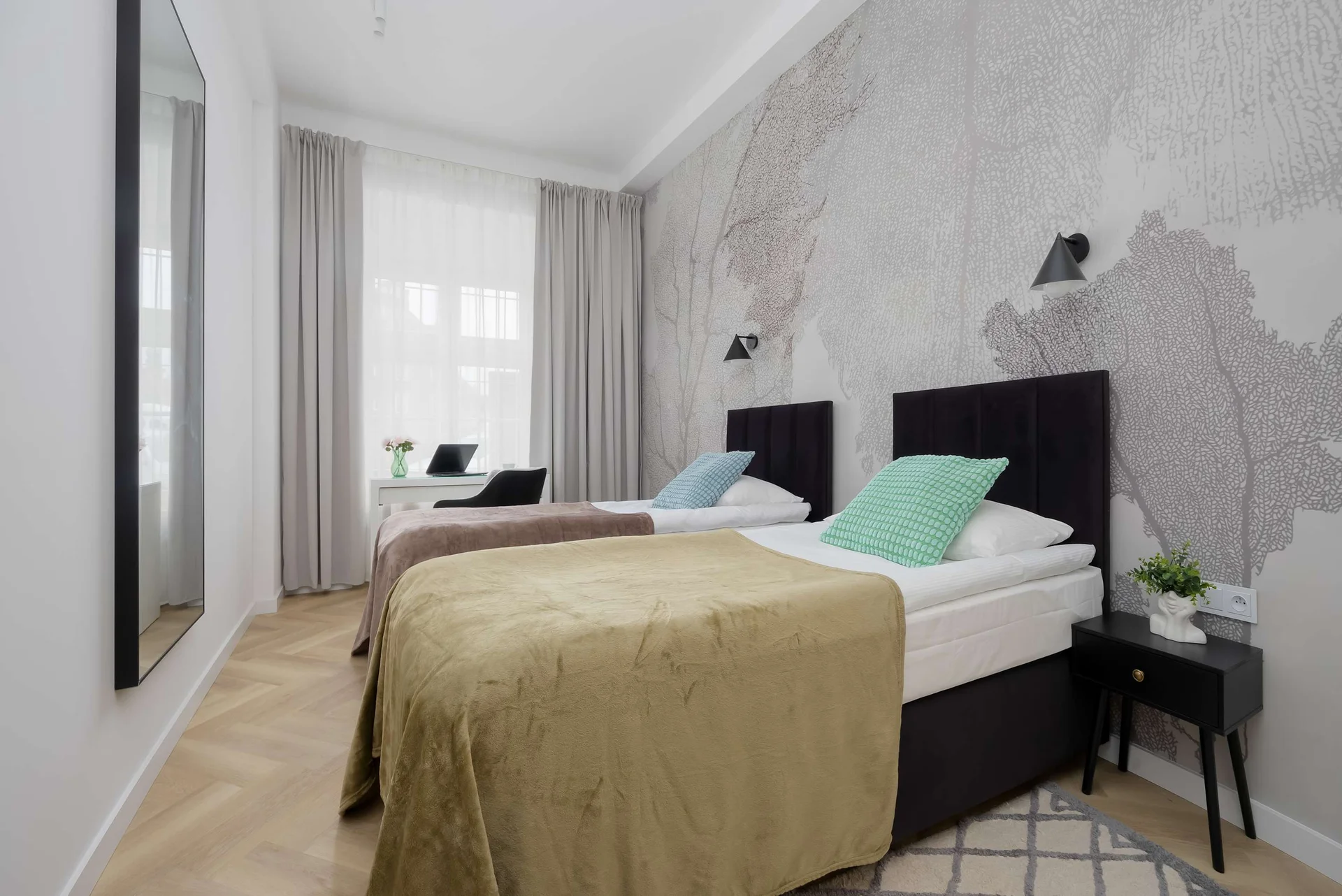 Bright bedroom featuring two single beds and modern décor.