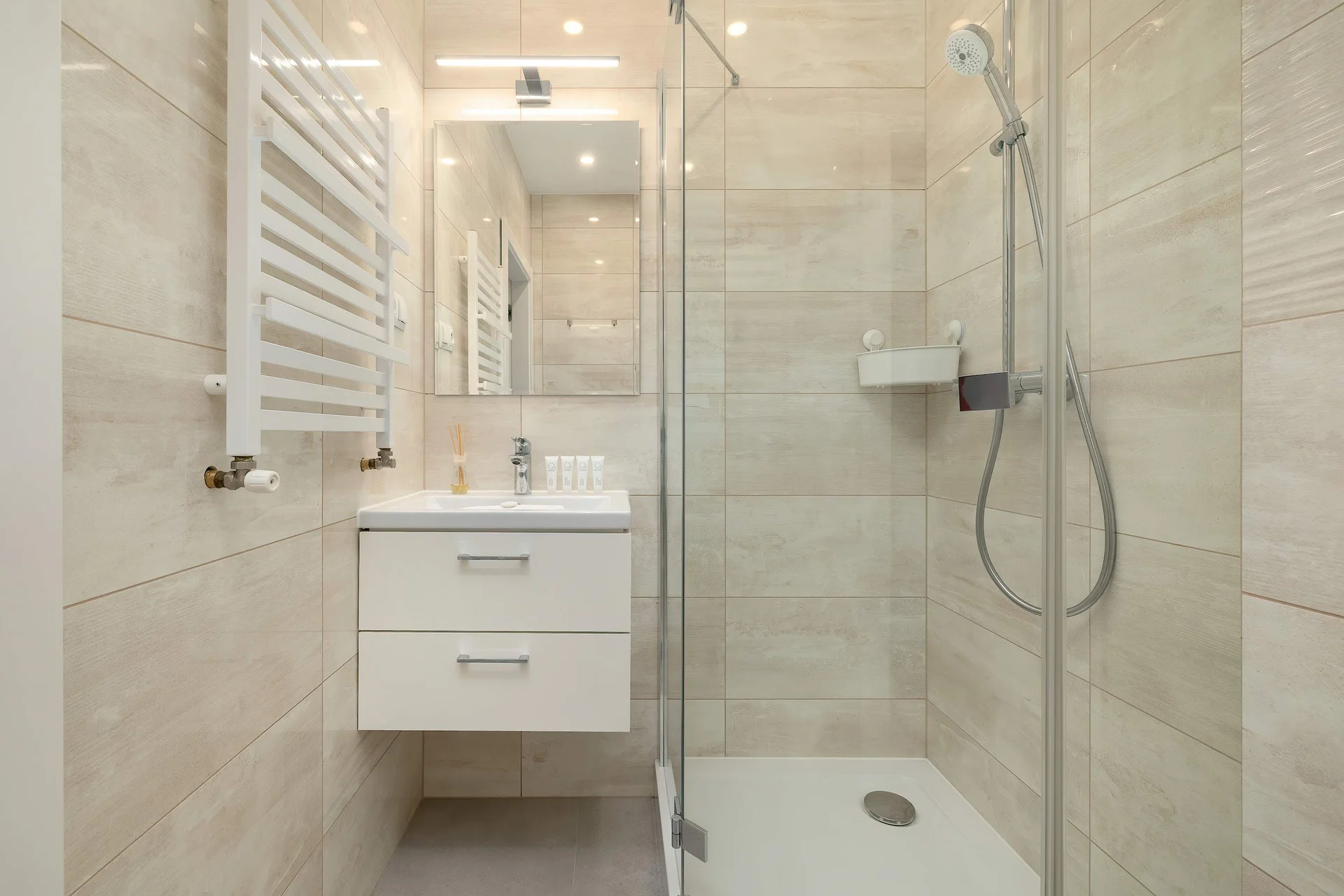 The bathroom's contemporary design includes fresh towels and a hairdryer.