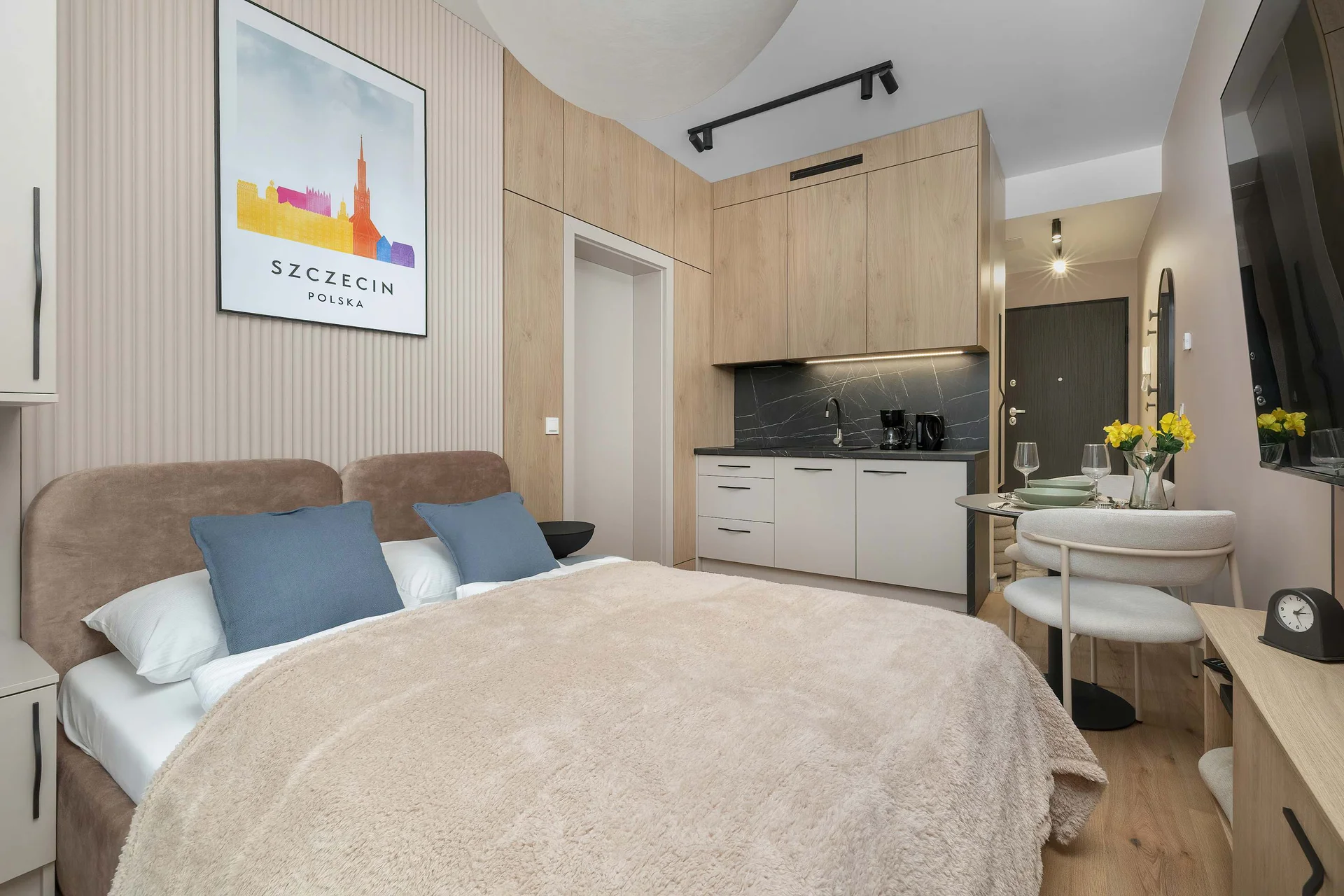 The living area features a sleek table and a flat-screen television.