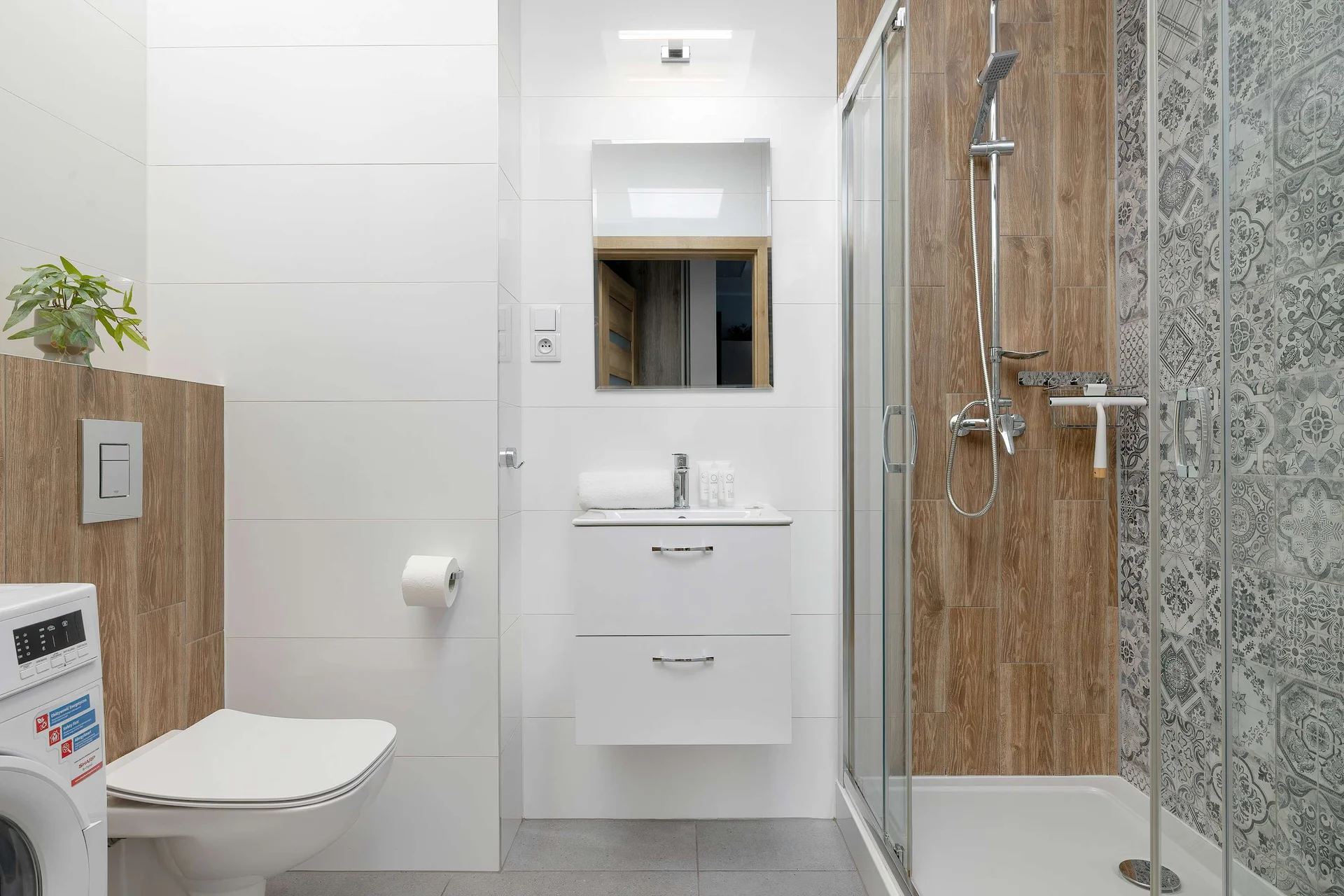 The bathroom's contemporary design includes fresh towels and a hairdryer.