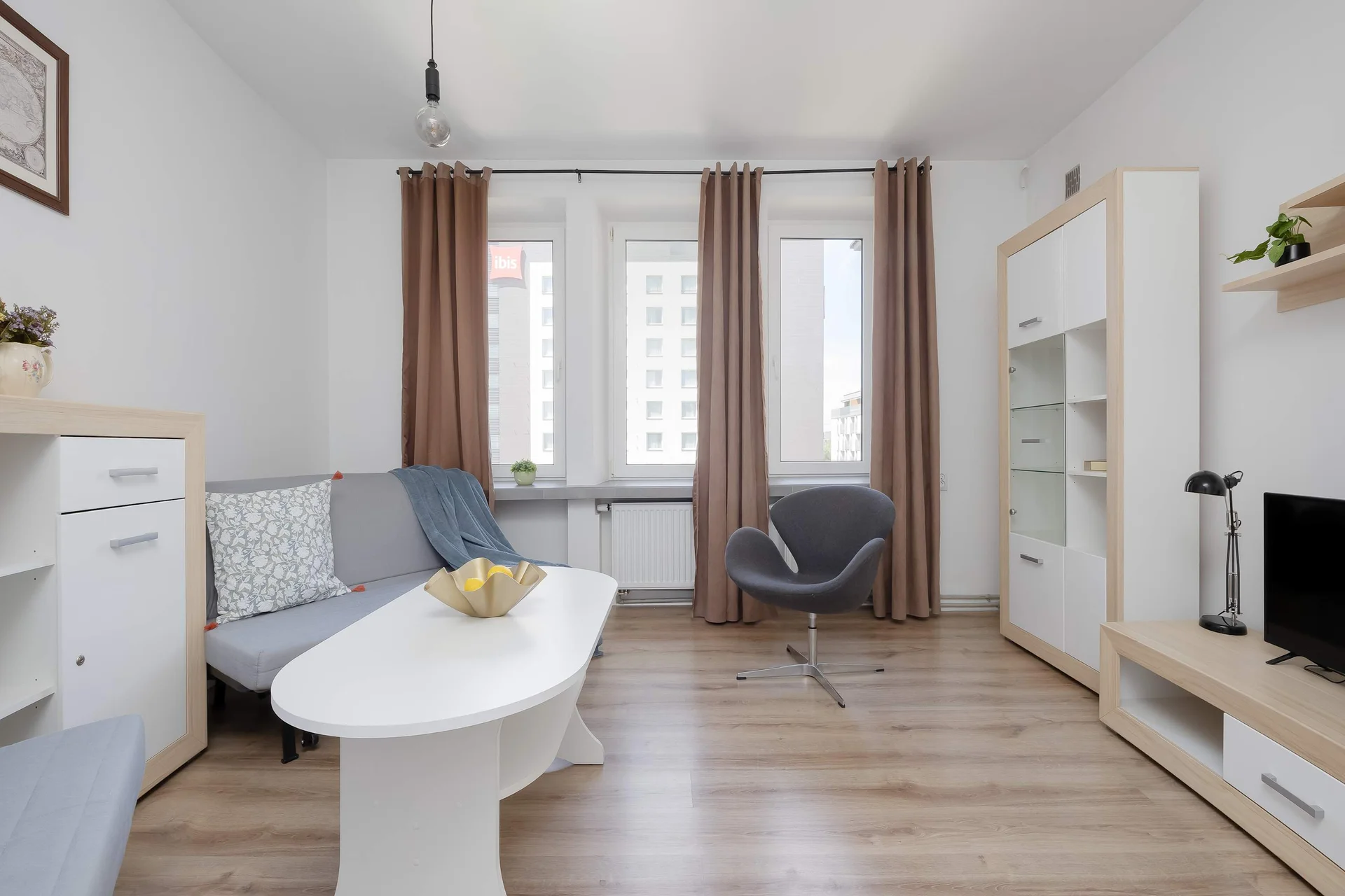 View of the second bedroom showing two sofa beds, dining space, and access to the apartment’s main area.
