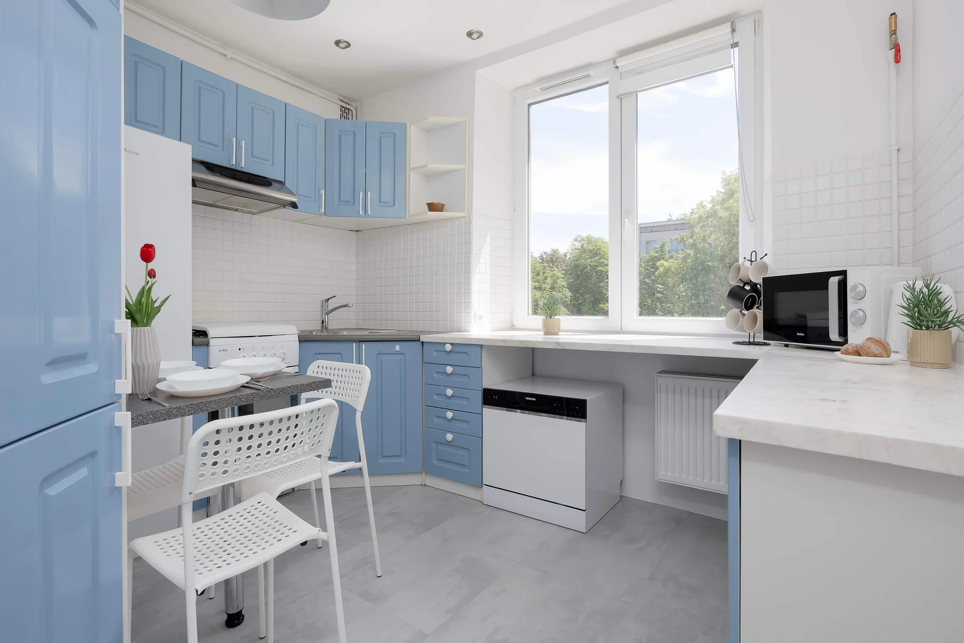 Fully equipped separate kitchen with modern appliances, ample storage space, and a dining area.