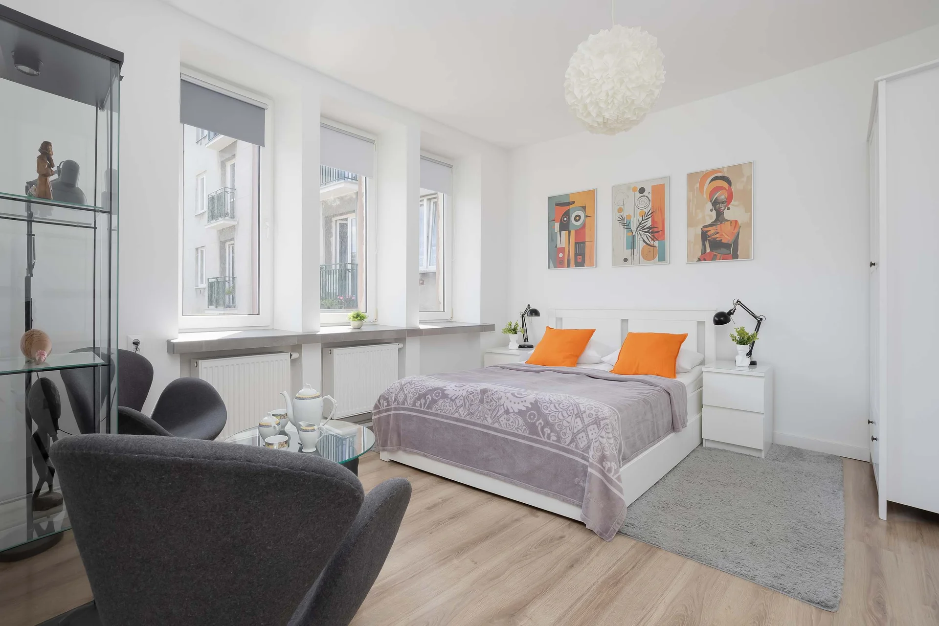 Spacious master bedroom with a comfortable double bed, elegant décor, and large windows overlooking the courtyard.