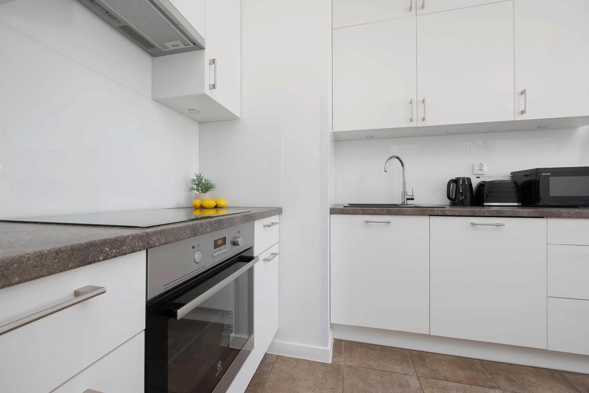 Modern kitchenette with essential appliances and ample storage.