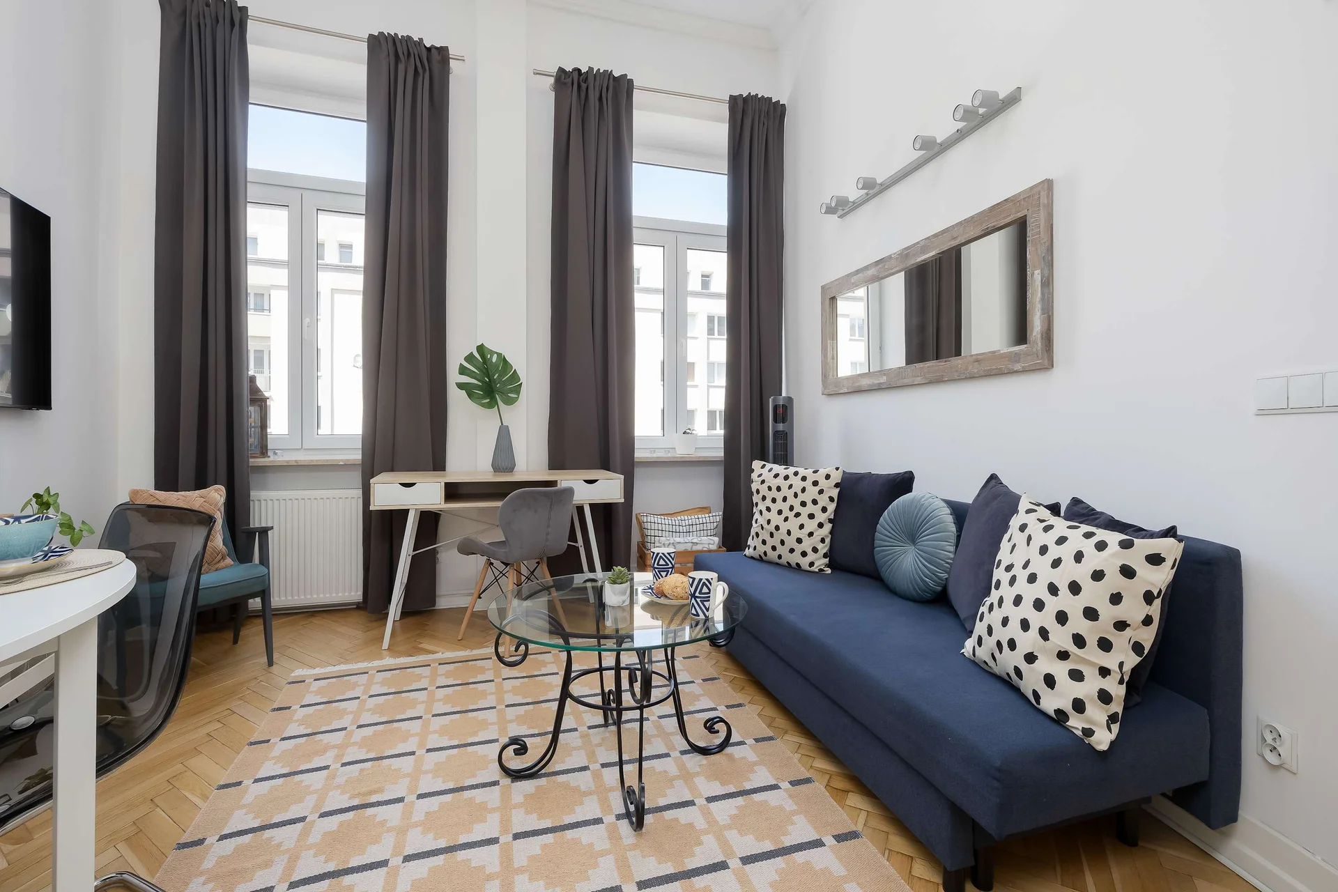 Bright living area with a comfortable sofa, dining table, and large windows.