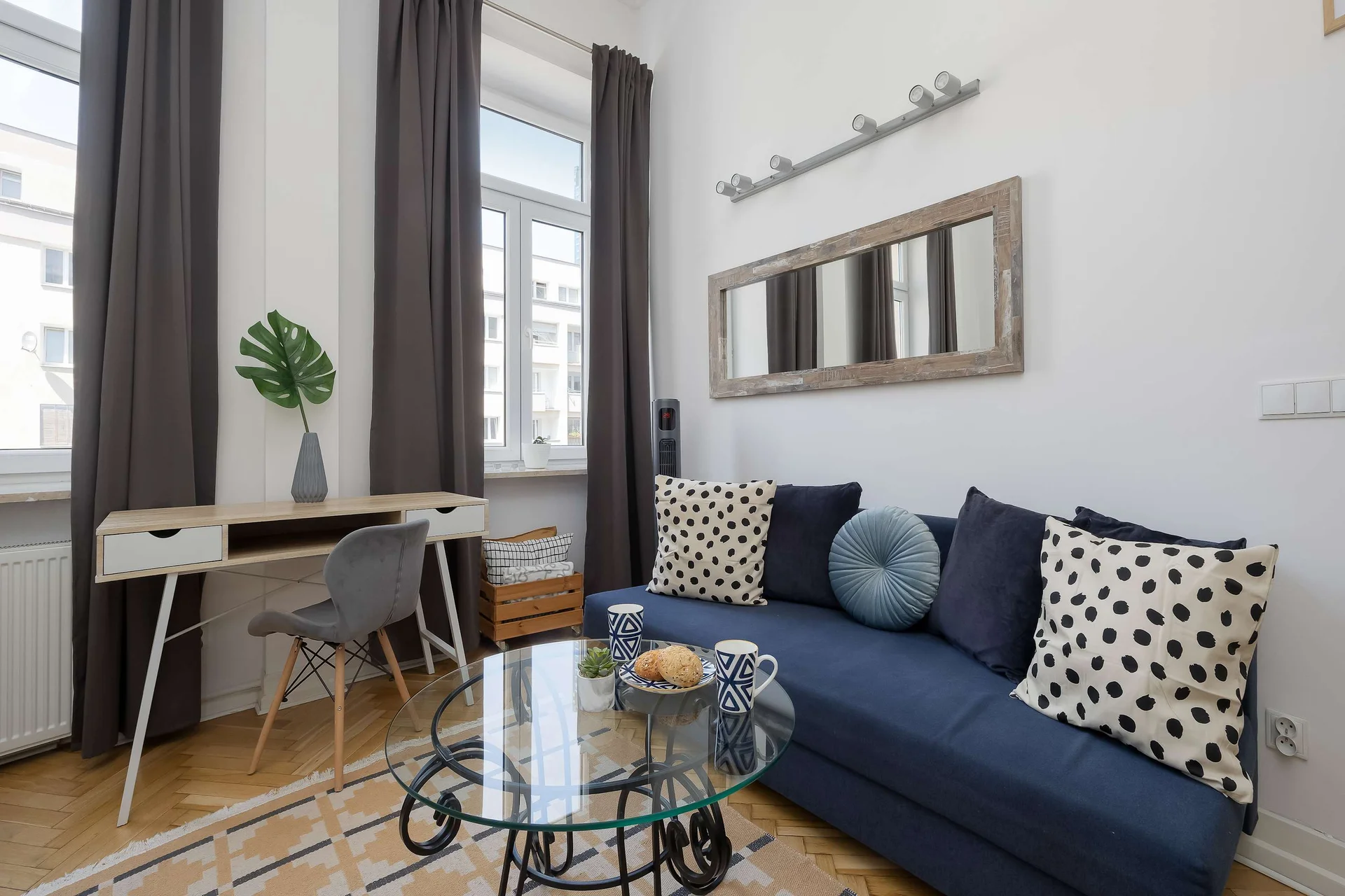 Bright living area with a comfortable sofa, dining table, and large windows.