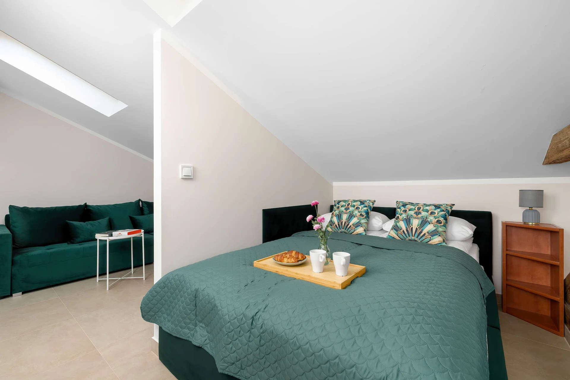 Comfortable double bed with premium linens in a bright studio apartment with charming attic character.
