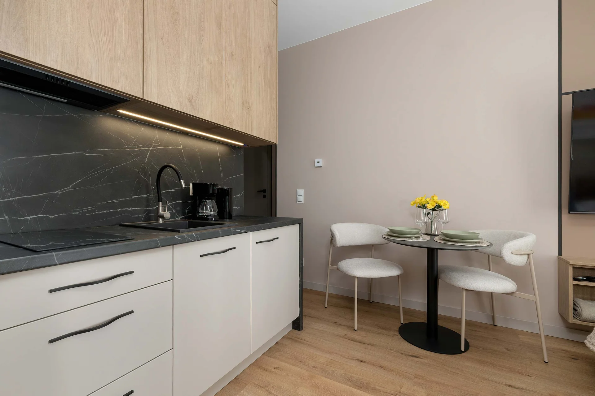 The sleek design of the kitchenette blending seamlessly with the living area.