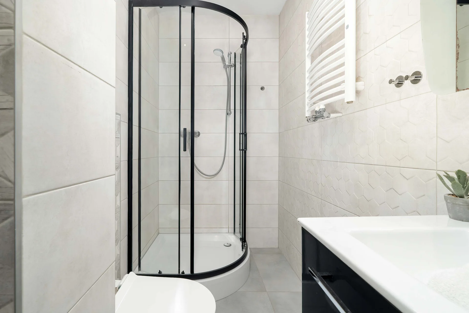 Elegant bathroom with a walk-in shower, vanity sink and modern tiled interior.