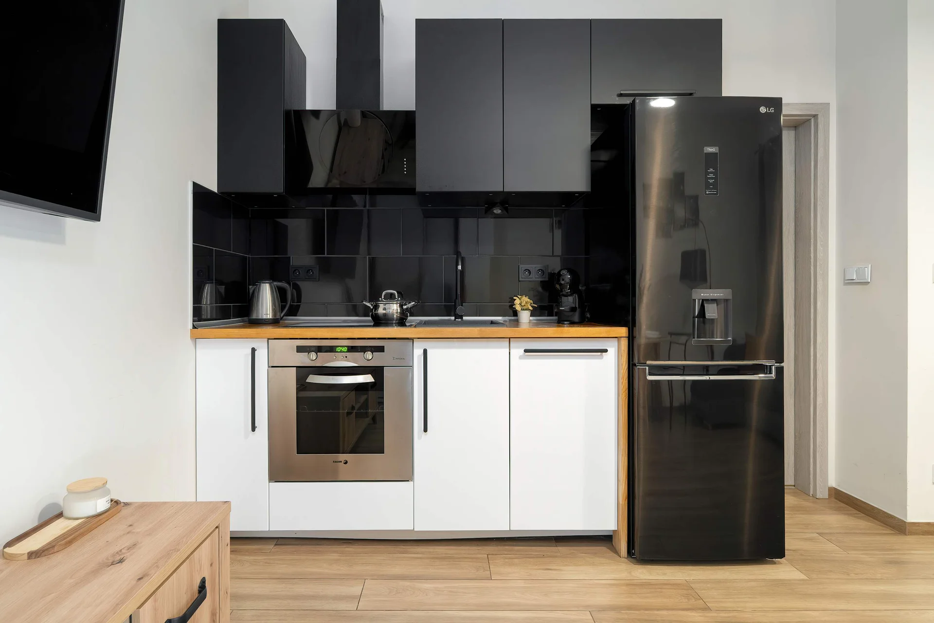 Contemporary kitchen with sleek black finishes, quality appliances and practical workspace.