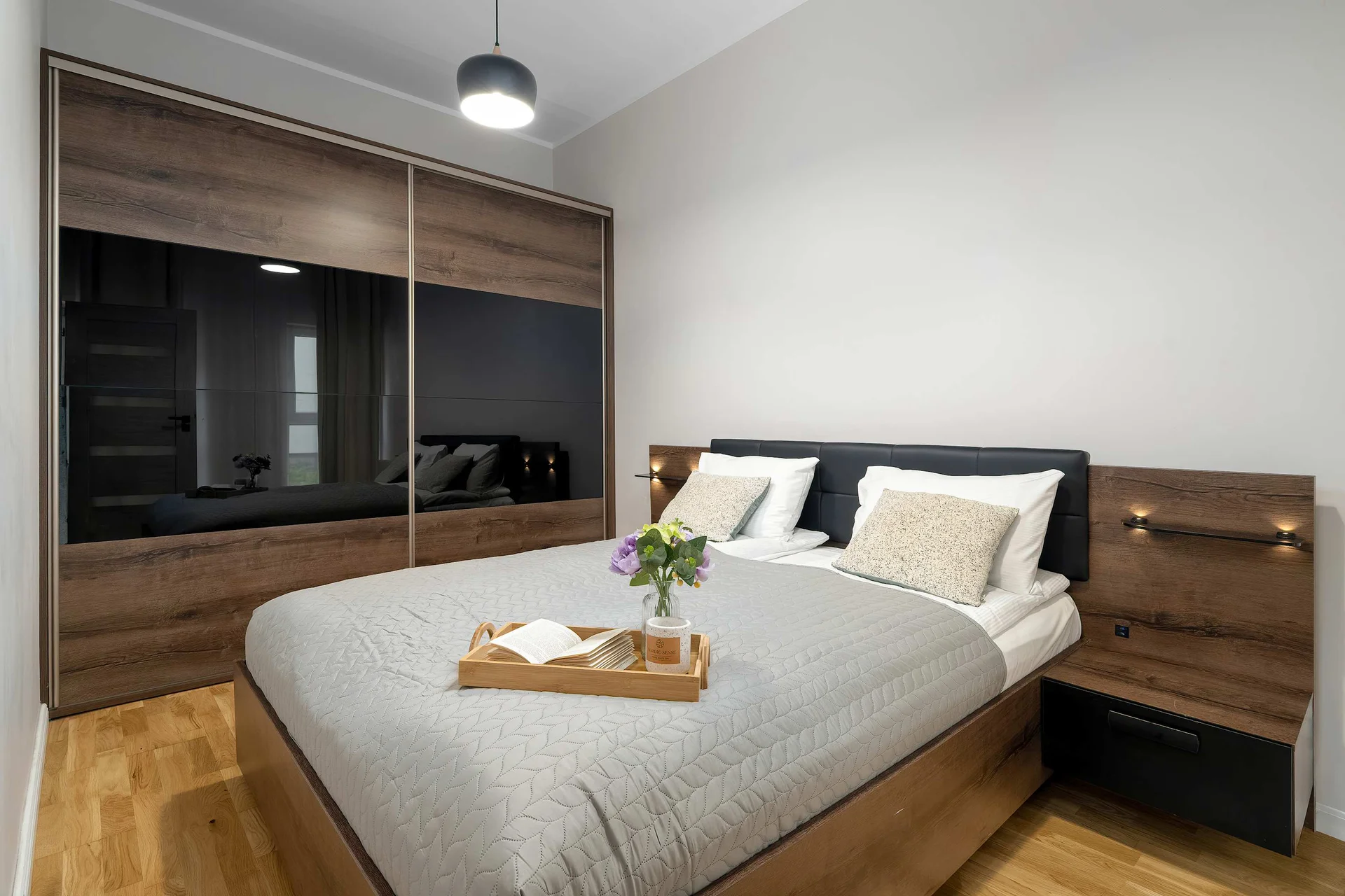 Cozy bedroom featuring a comfortable double bed, spacious wardrobe and warm ambient lighting.