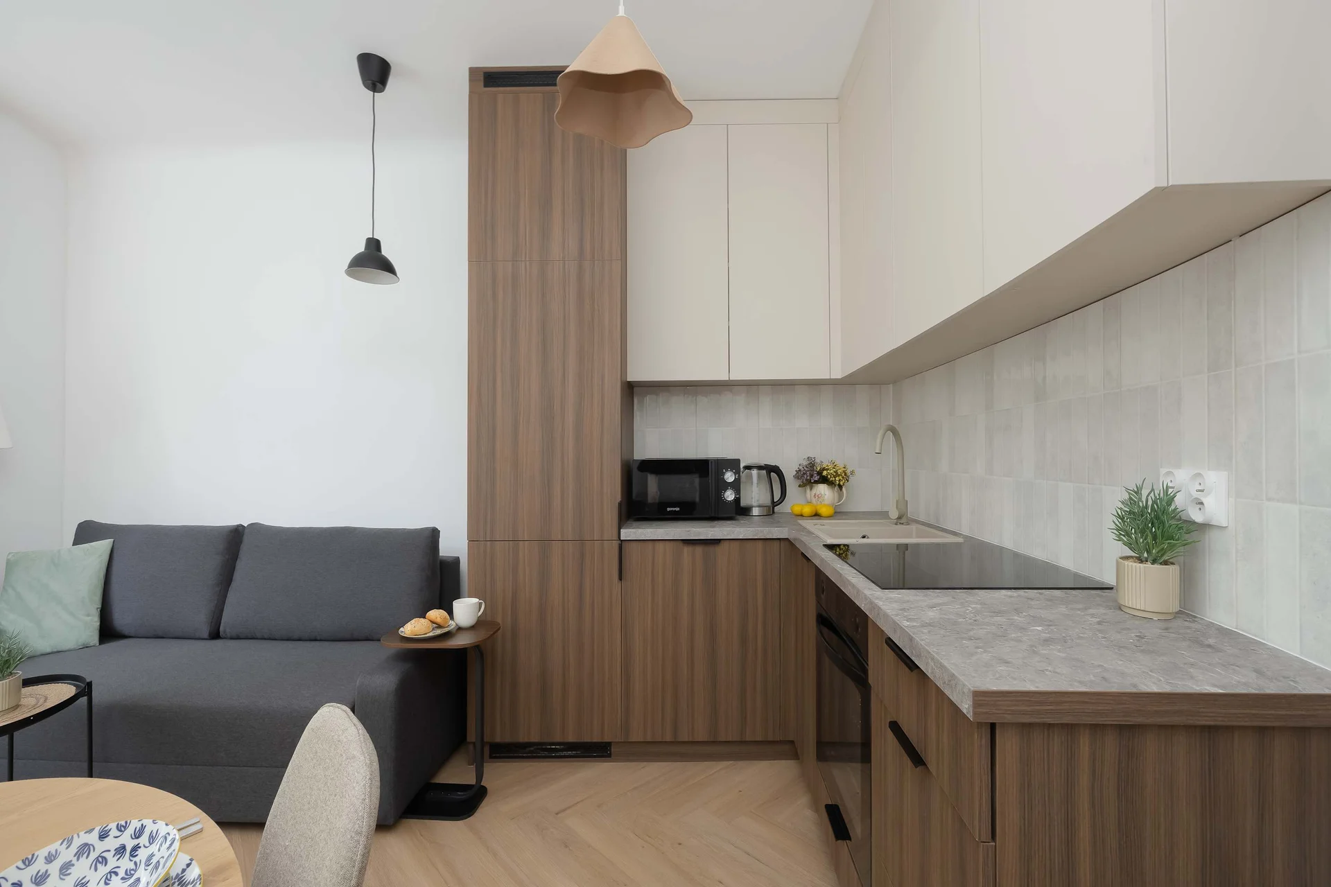 A modern kitchenette with plenty of storage and all the essentials for preparing meals. The cozy sofa creates a welcoming space to unwind after a day of sightseeing.