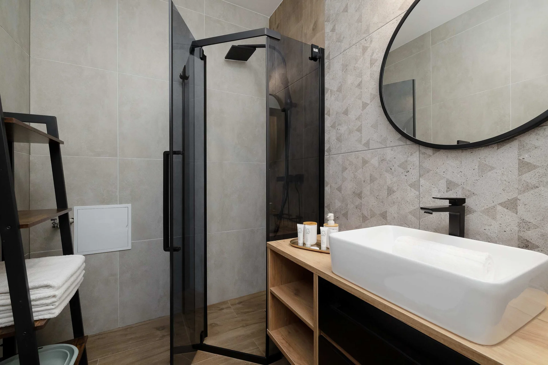 The bathroom's contemporary design includes fresh towels and a hairdryer.
