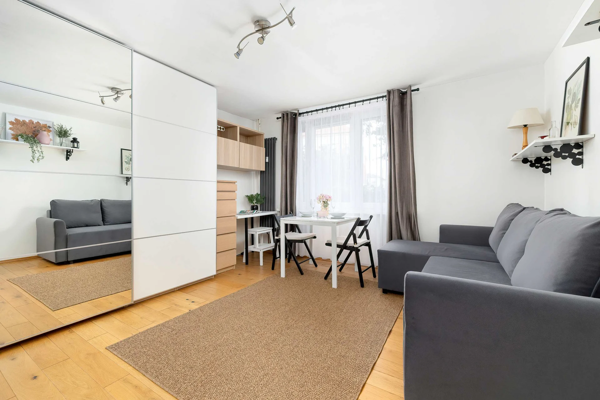 The living area features a sleek table and a flat-screen television.