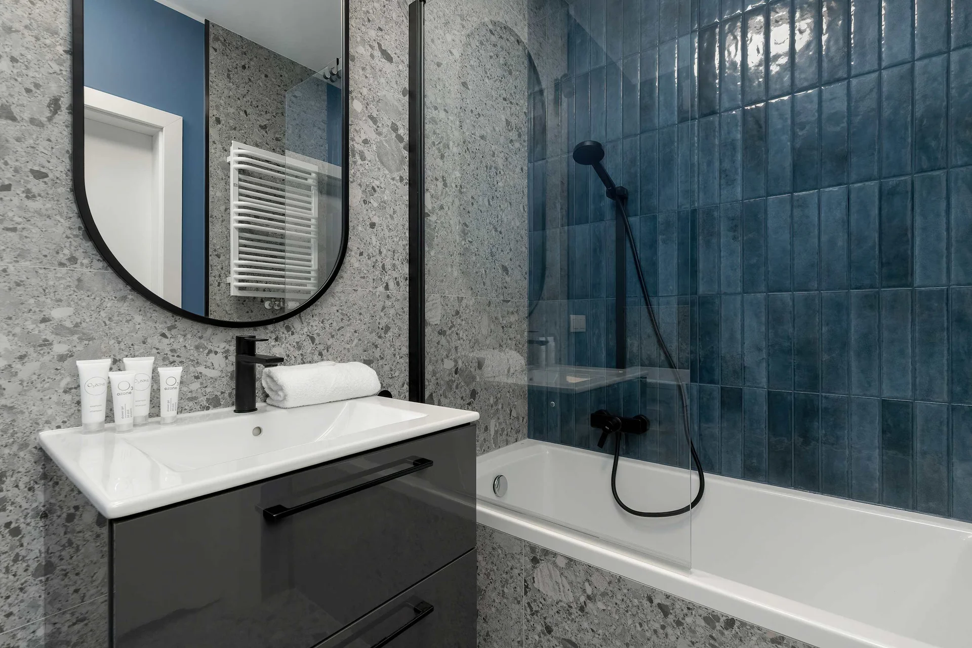 The bathroom's contemporary design includes fresh towels and a hairdryer.