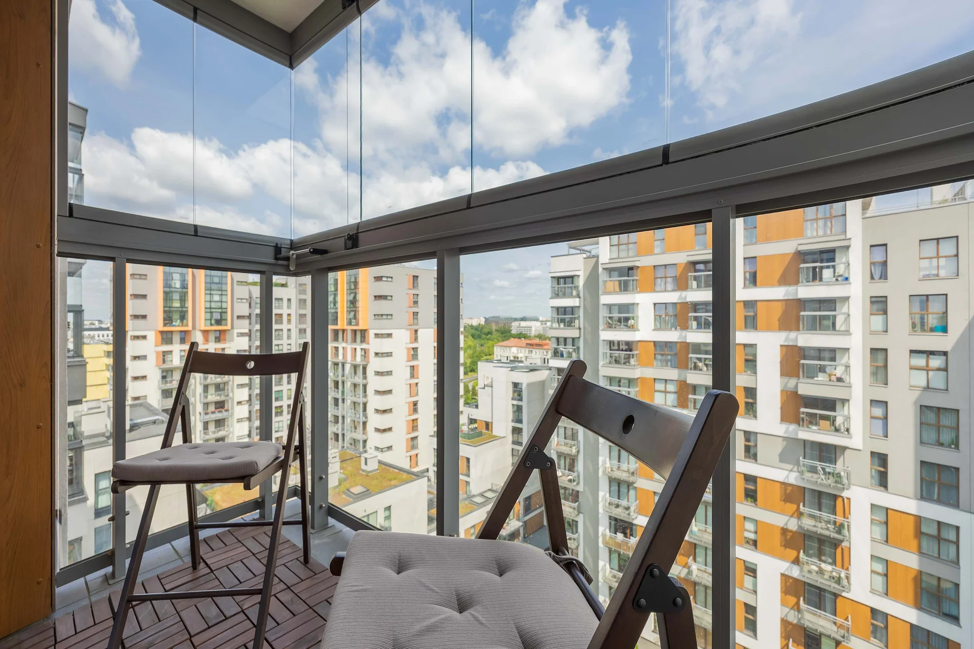 Private covered balcony with comfortable outdoor seating and lovely views of the surrounding buildings.