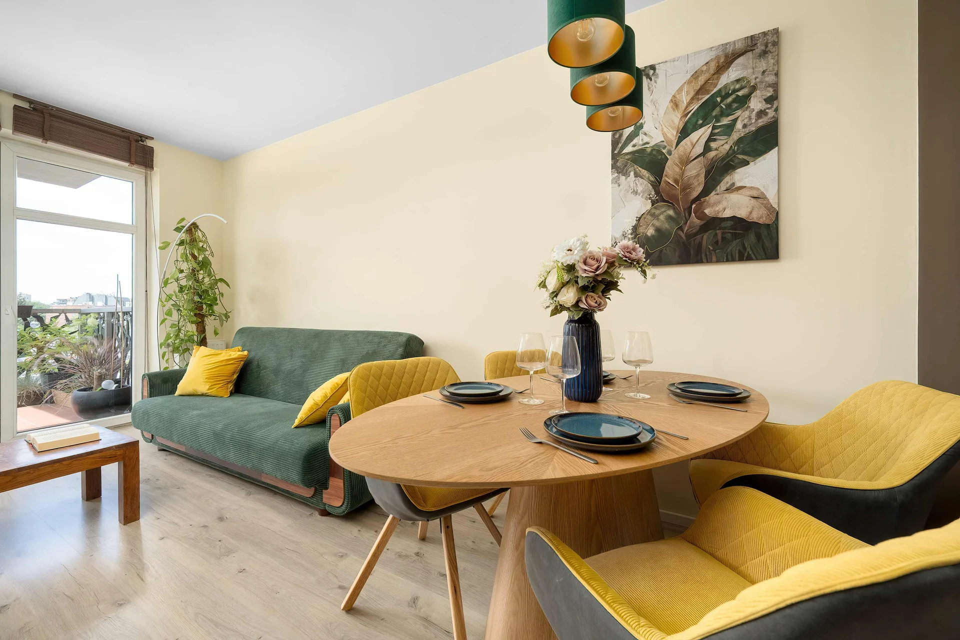 Bright living room with a dining table, comfortable seating, and large windows overlooking the neighborhood.