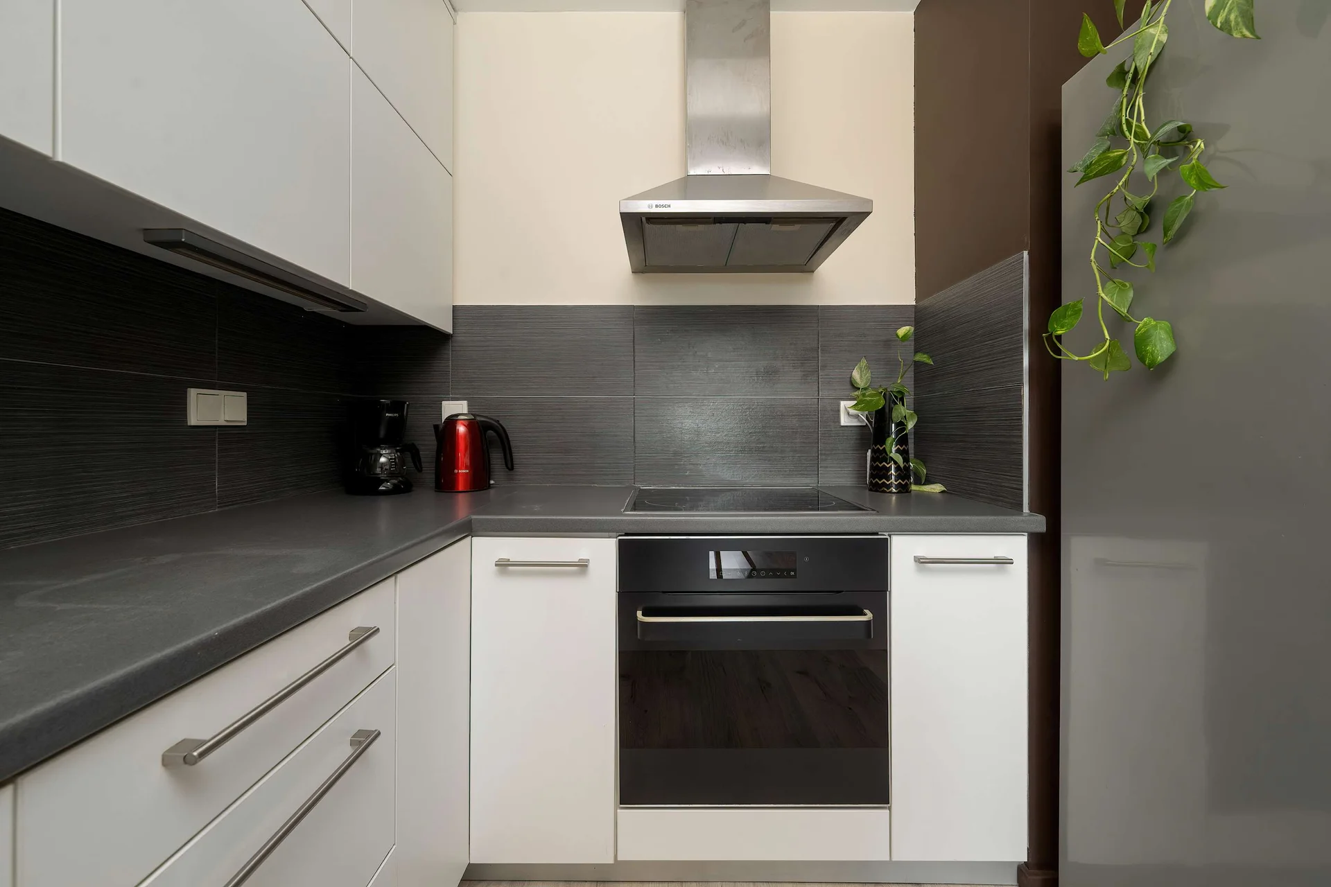 Modern kitchenette with built-in appliances, generous countertop space, and sleek cabinetry.