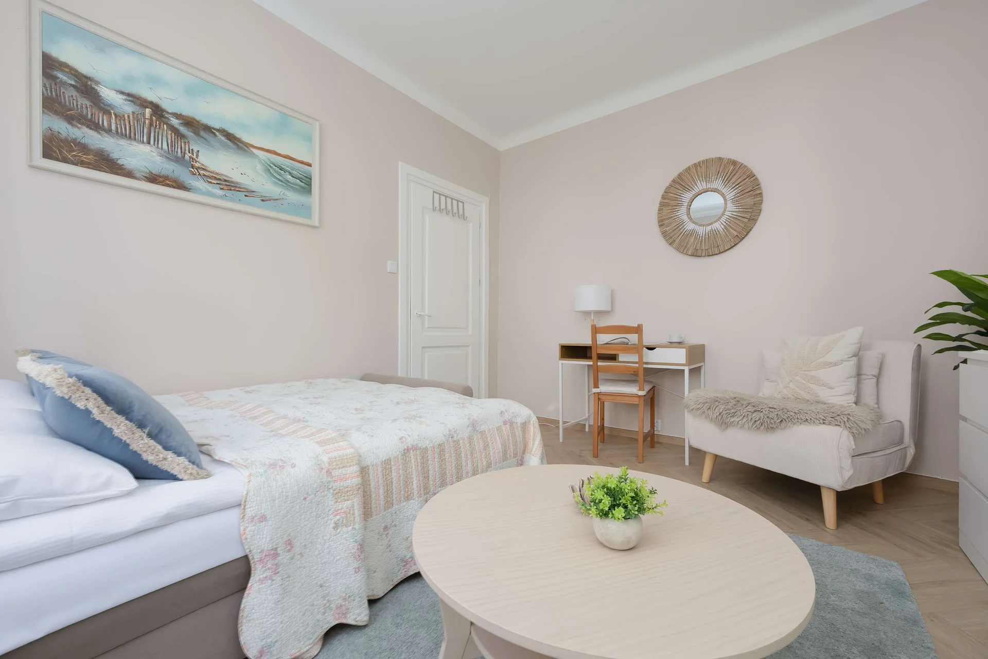 Looking across the room emphasizes the smooth transition from the bed area toward the study desk and armchair. The neutral wall tones and light flooring enhance the room's bright and open feel.