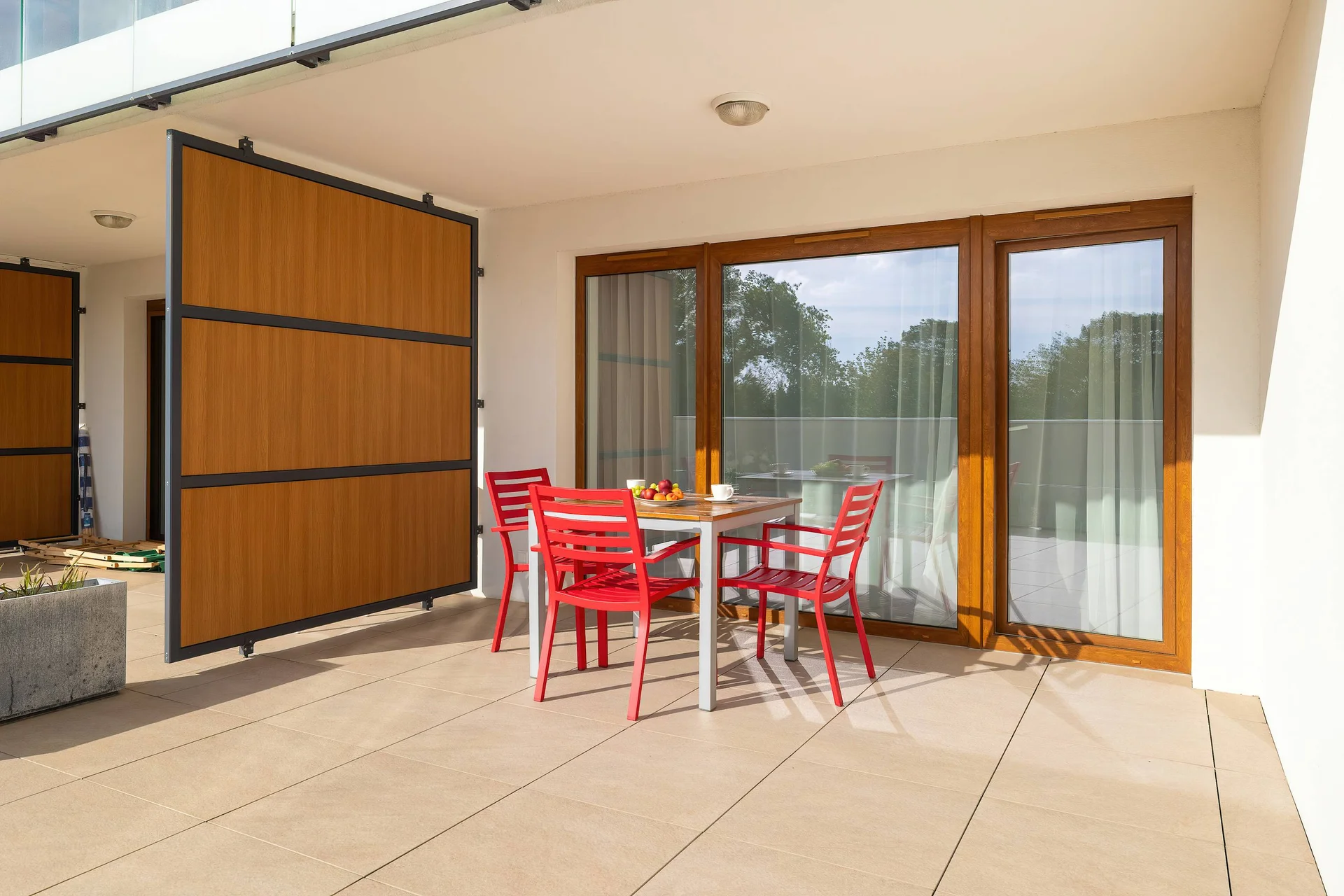 A sunny terrace with a table and chairs overlooking the open area. It provides a perfect extension of the apartment for outdoor relaxation.
