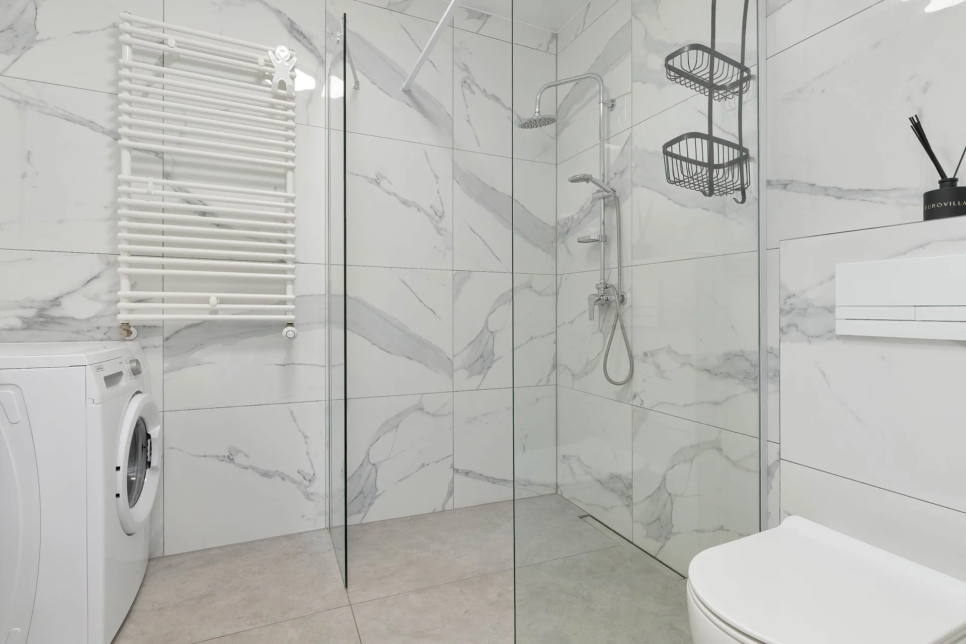 The bathroom's contemporary design includes fresh towels and a hairdryer.