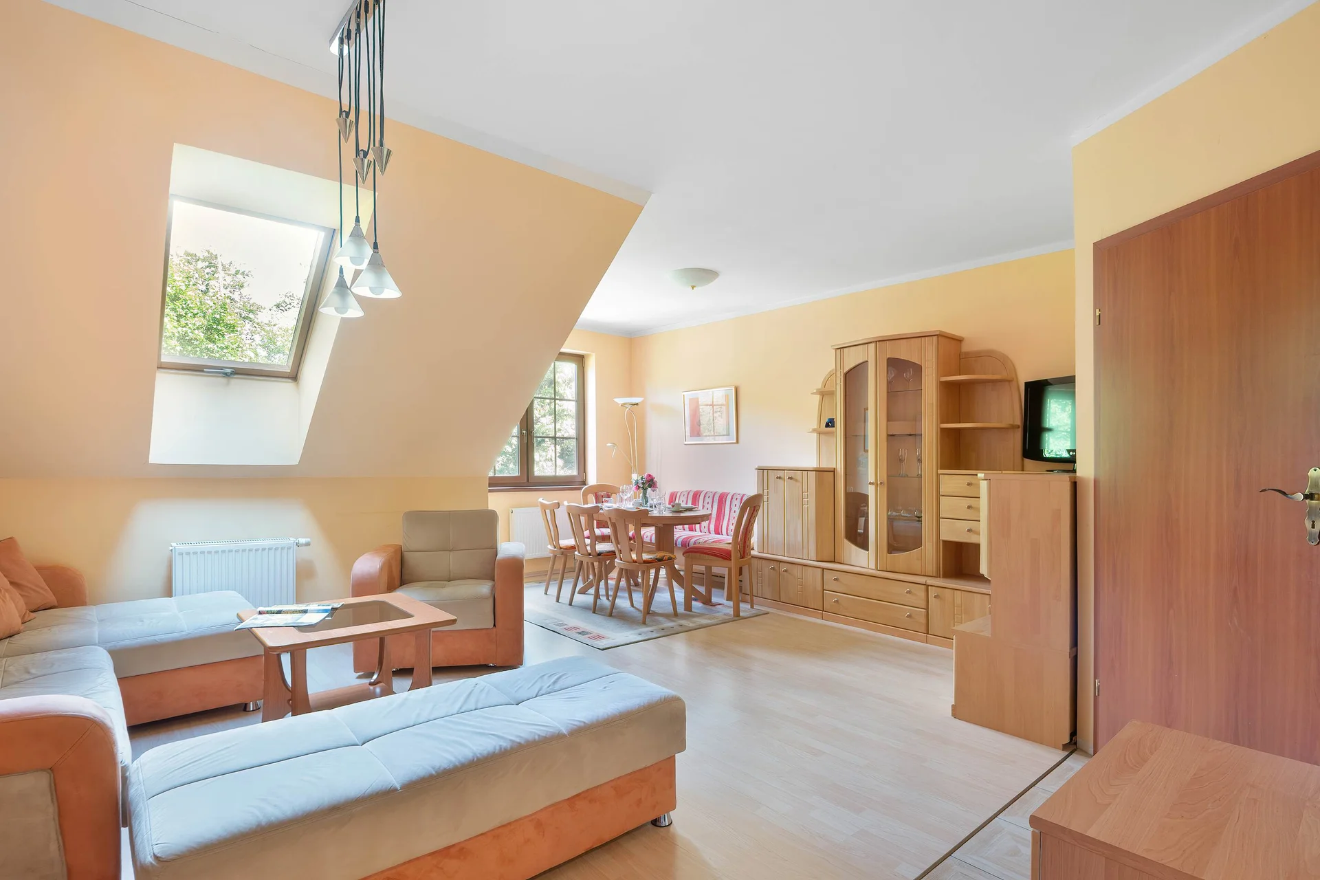 A bright living room with comfortable seating and an open layout. Large windows let in plenty of daylight.