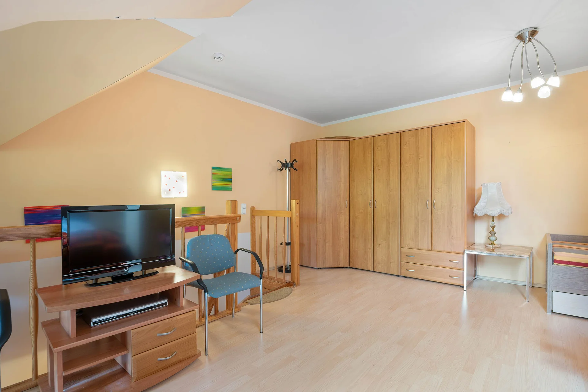 A bright lounge with a TV, wardrobe, and comfortable seating. The functional layout makes everyday living easy.