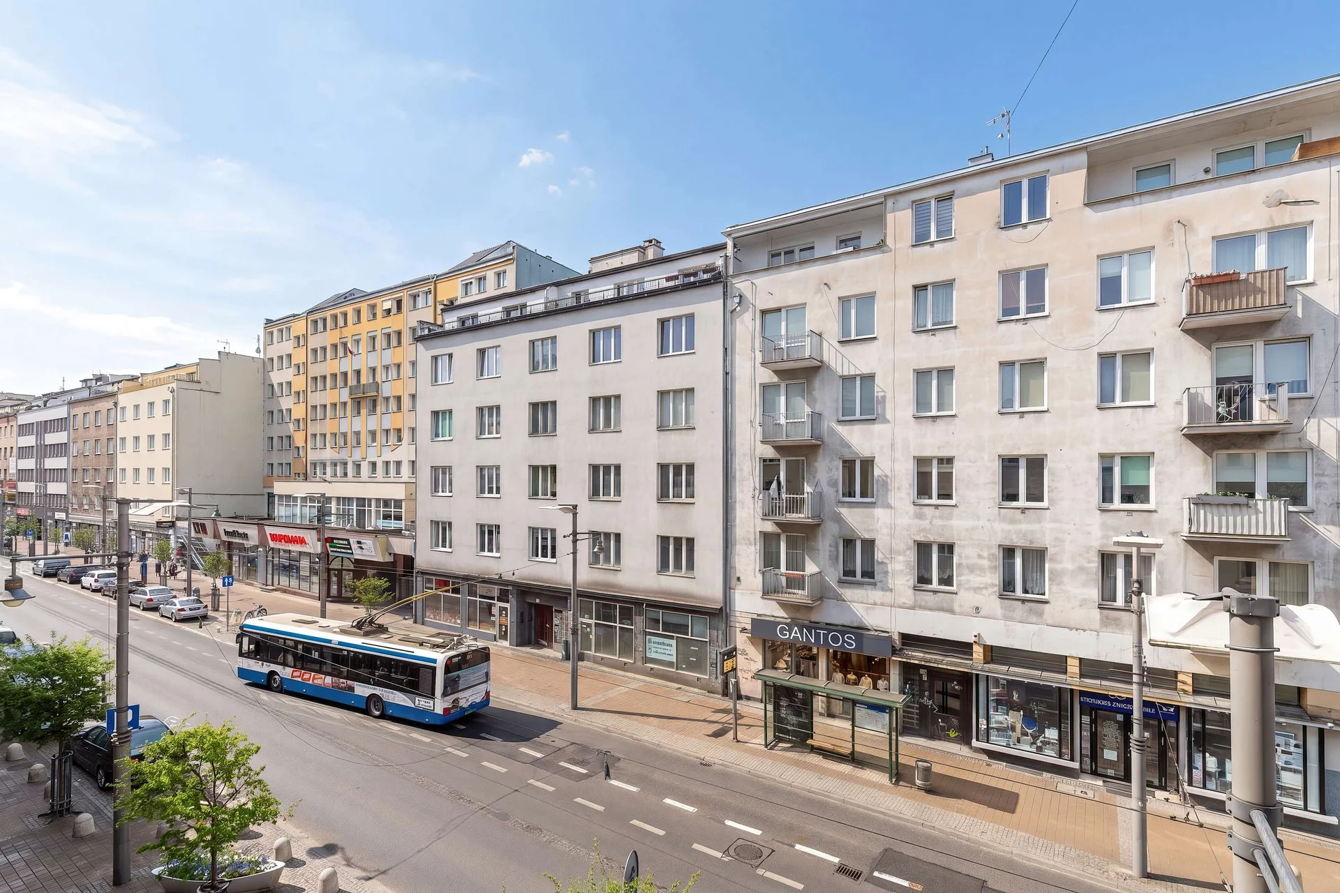 A modern city street lined with apartment buildings creates an urban atmosphere. Balconies and large windows give the area a contemporary look.