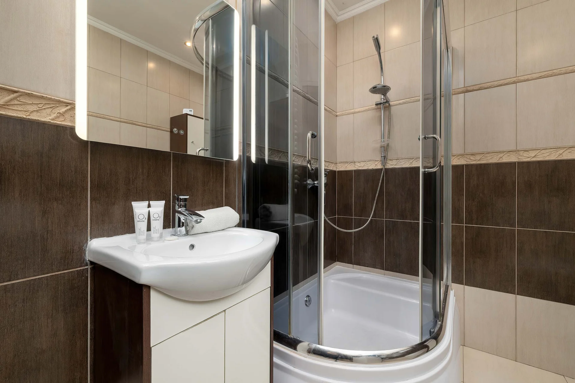 The bathroom's contemporary design includes fresh towels and a hairdryer.