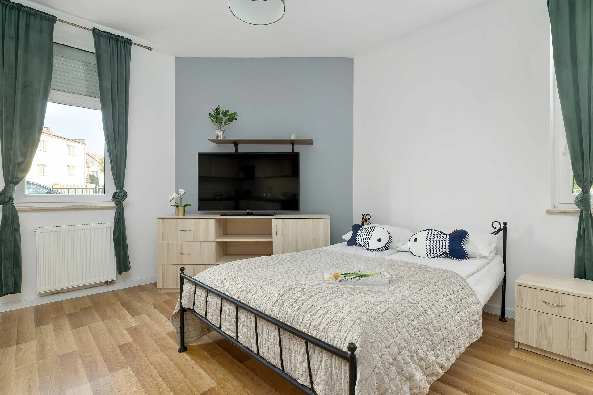 Bright and comfortable studio apartment with a cozy queen bed, large windows, and a relaxing seating area.