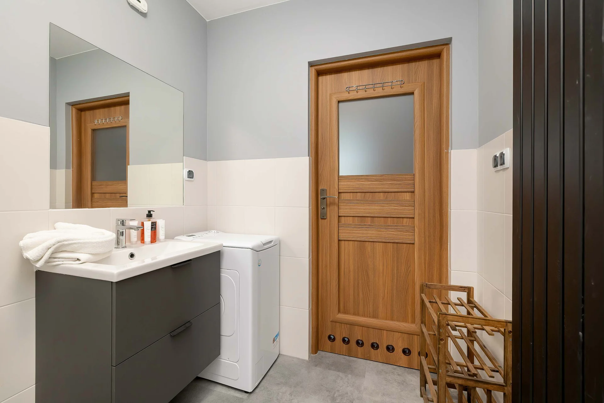 Modern bathroom with shower, washbasin, toilet, and storage space.