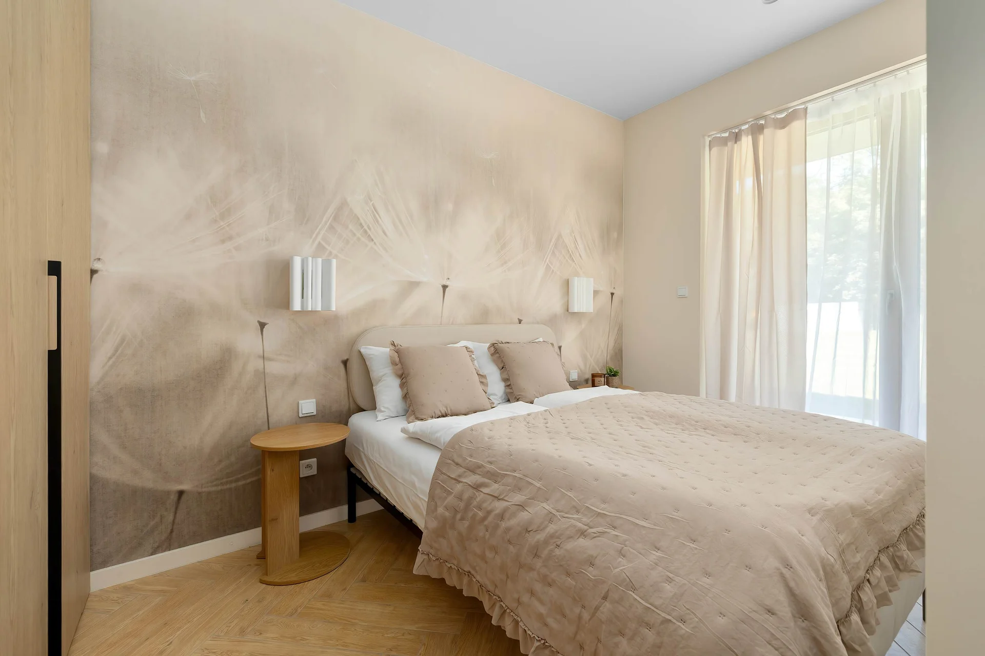 The sleeping area is viewed from another angle, highlighting the textured accent wall, comfortable bed, and elegant bedside lighting. Floor-to-ceiling curtains add a cozy touch.