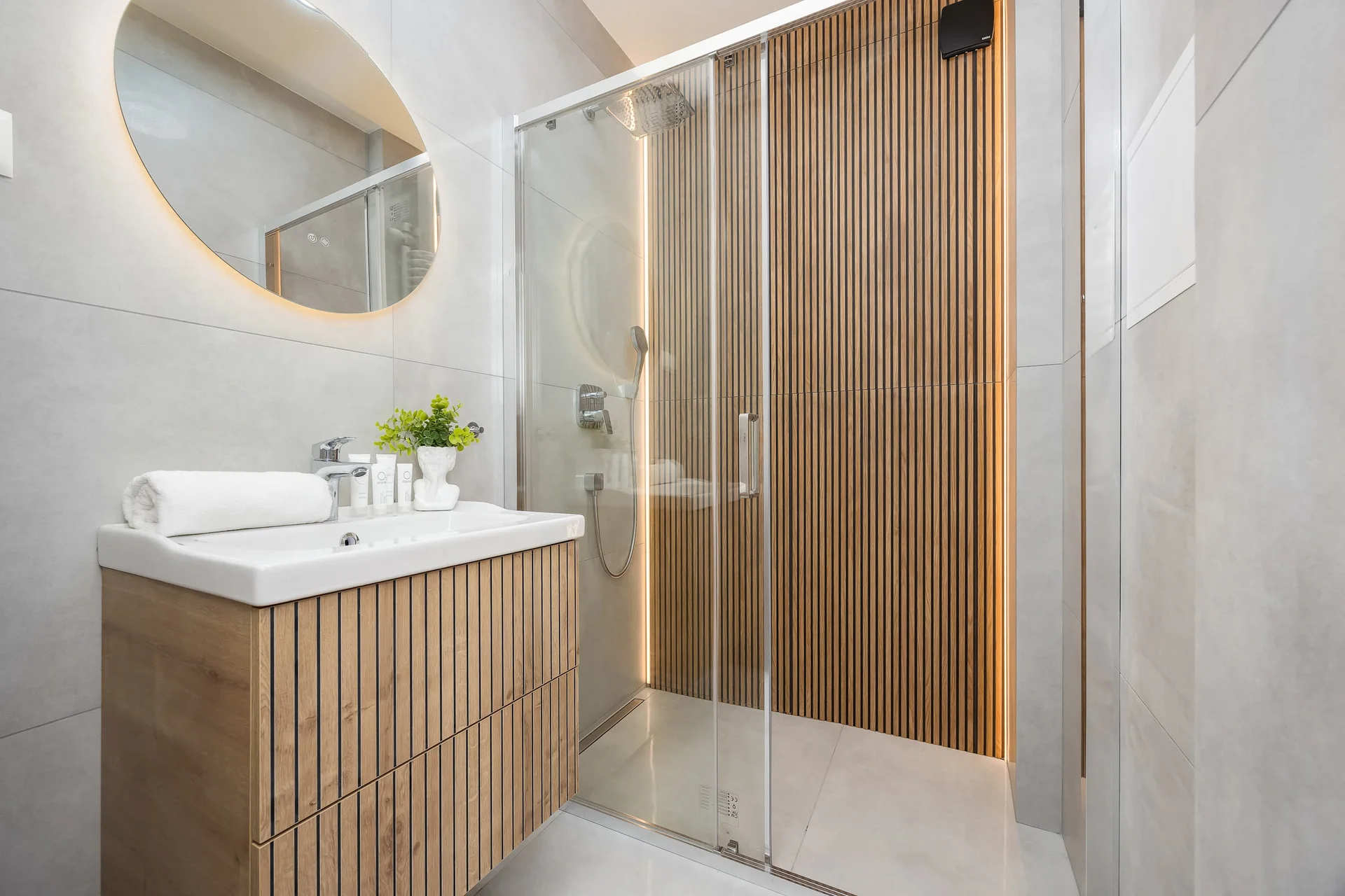 The bathroom's contemporary design includes fresh towels and a hairdryer.
