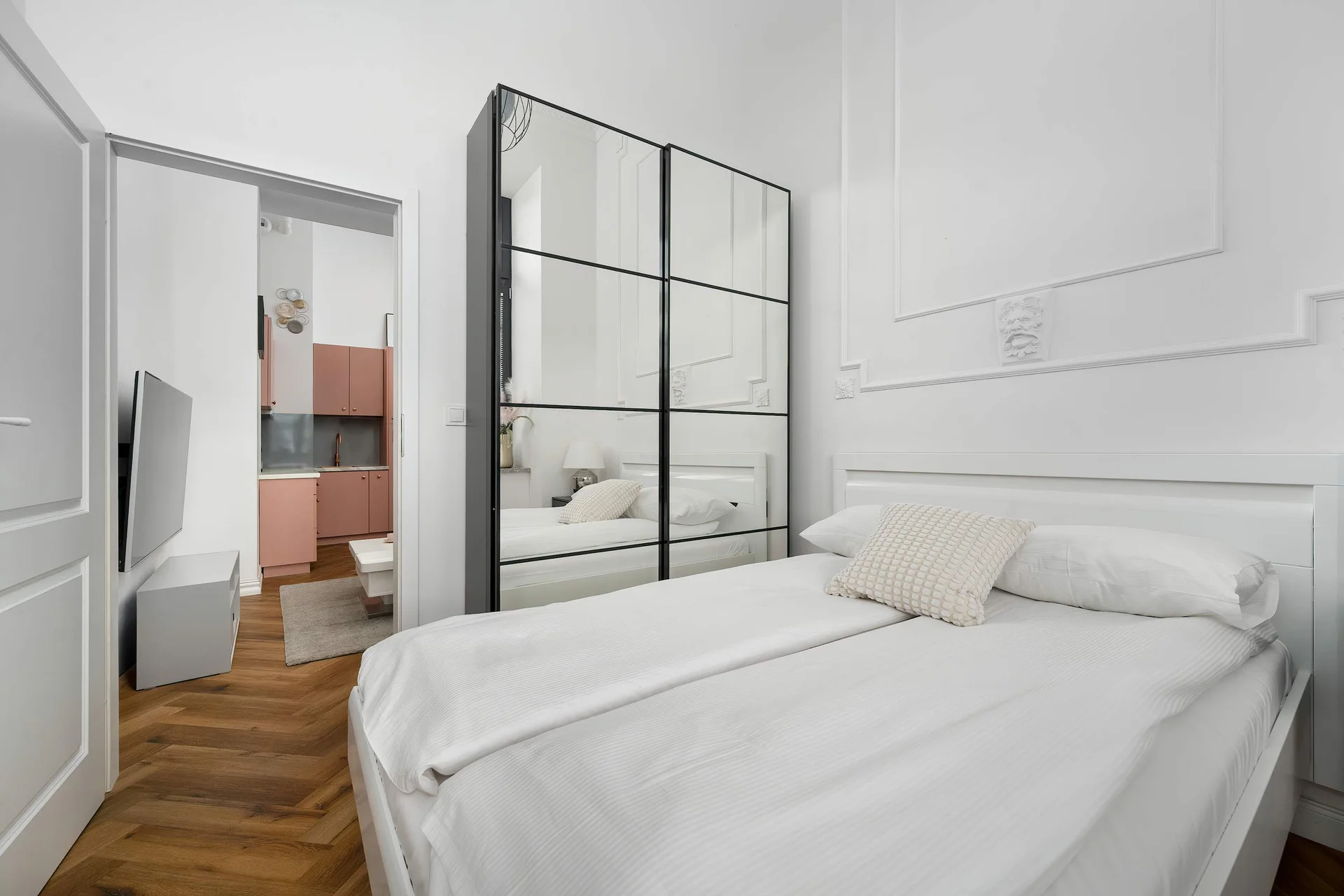 A modern bedroom with a double bed and a mirrored wardrobe. The bright interior creates a relaxing atmosphere.