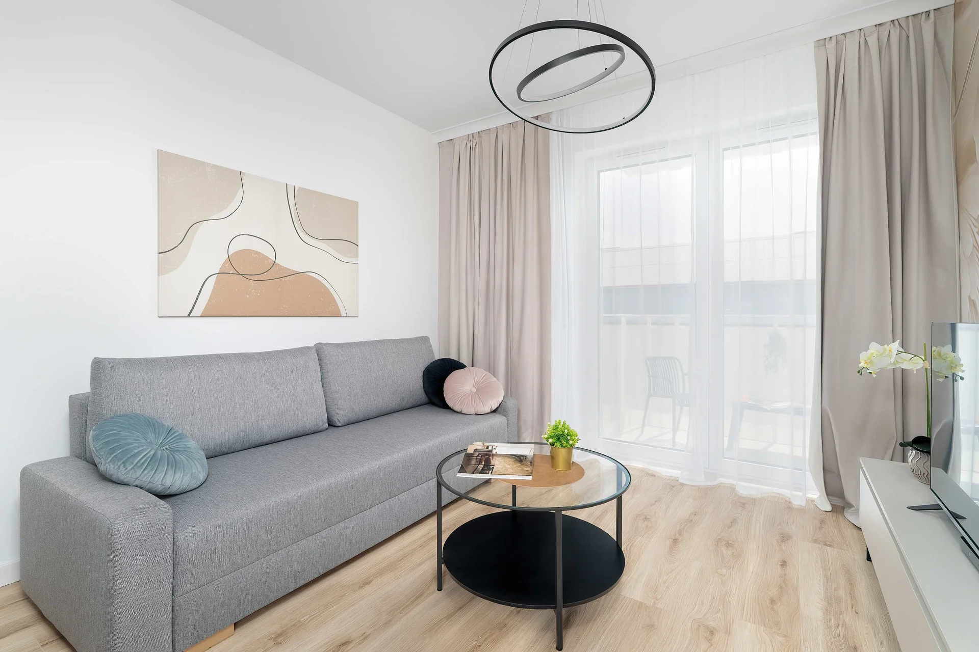 Bright and stylish living room with a comfortable sofa, elegant décor, and large windows providing plenty of natural light.