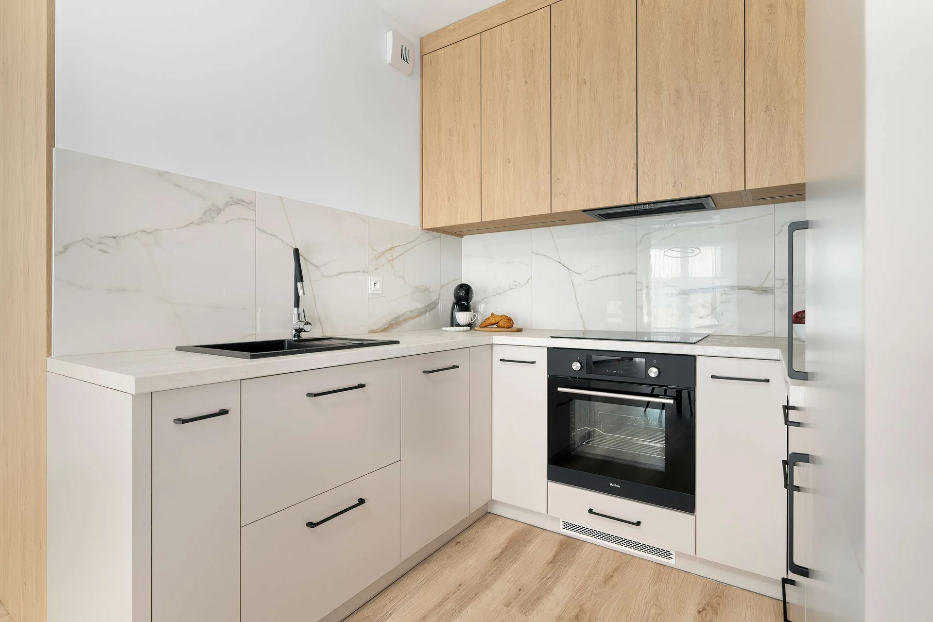 Modern kitchenette with wooden cabinetry, integrated appliances, and a practical layout.