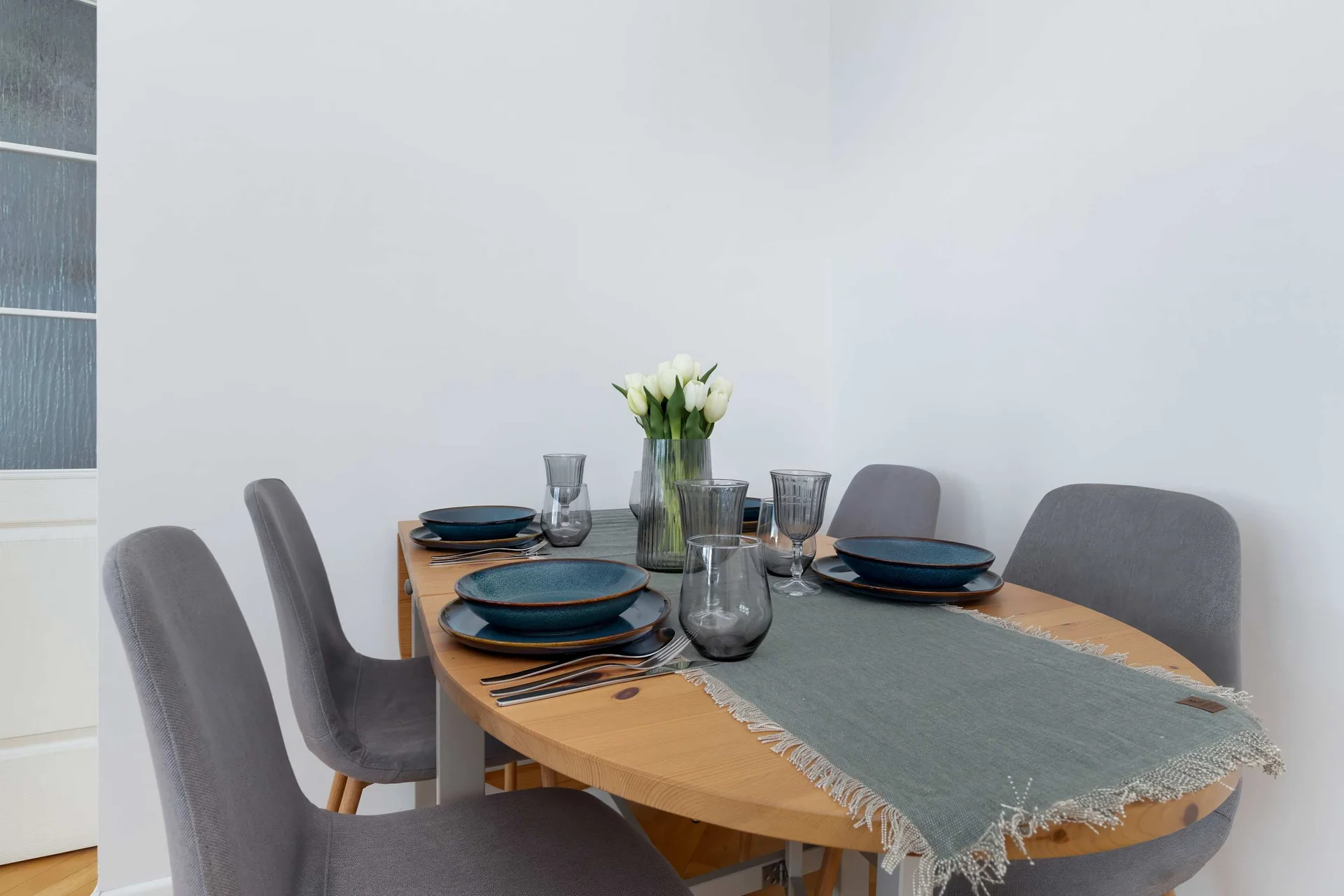 Dining area with a wooden table, upholstered chairs, and elegant table setting.