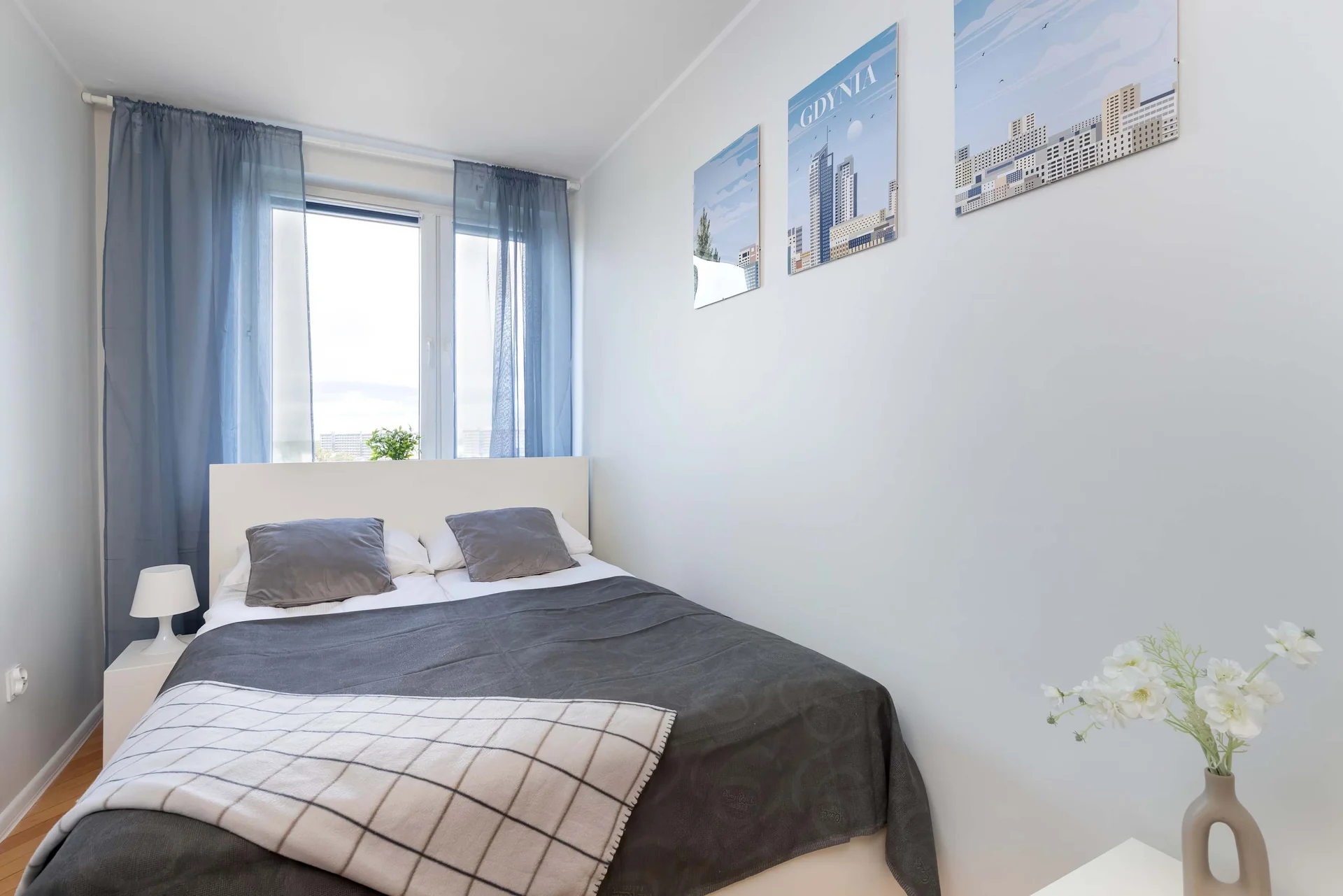 Bright bedroom with a comfortable double bed, large window, and modern furnishings.