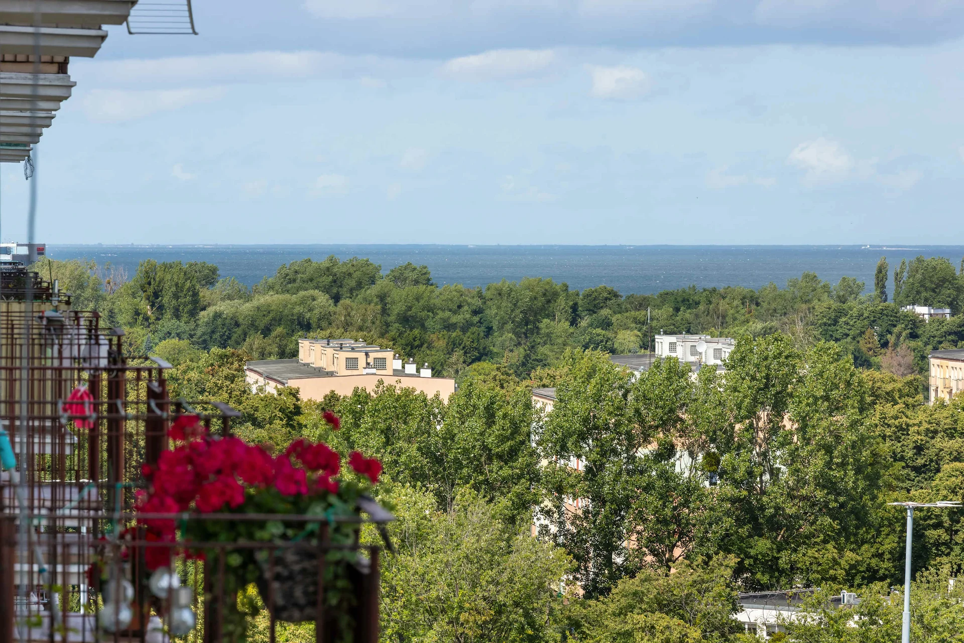 Balcony with beautiful panoramic views of the surrounding greenery, hills, and residential area.