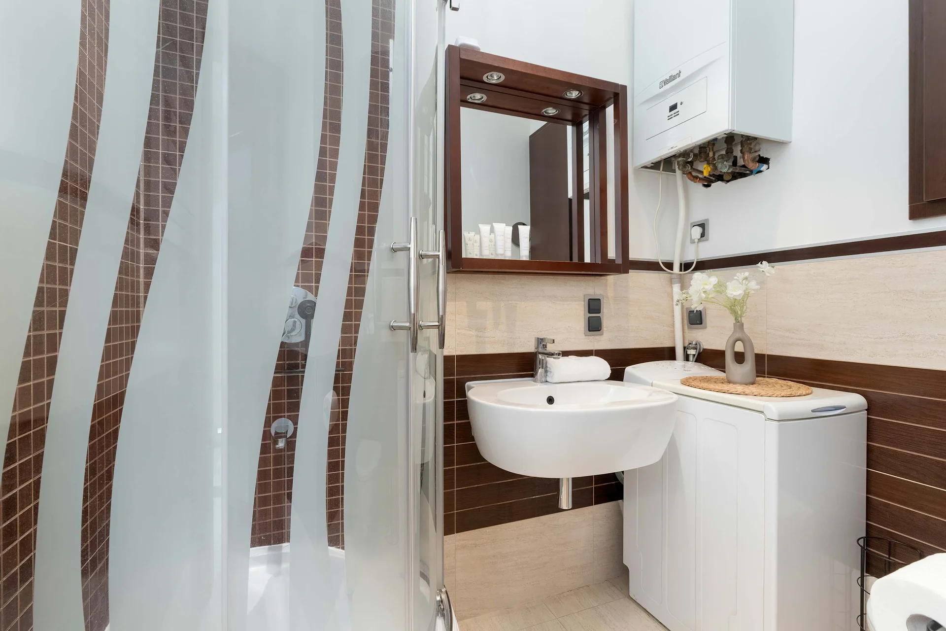 The bathroom's contemporary design includes fresh towels and a hairdryer.