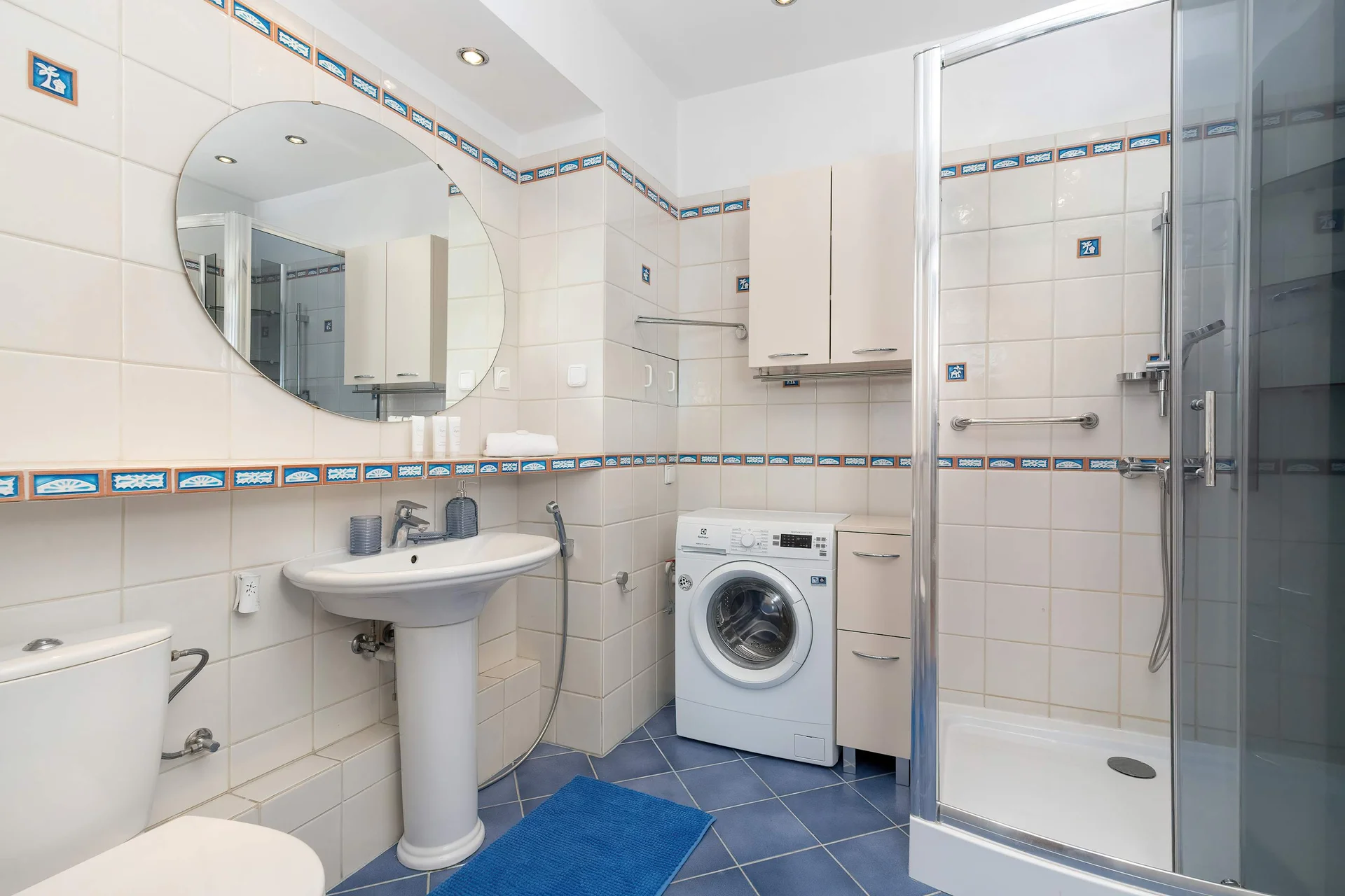 The bathroom's contemporary design includes fresh towels and a hairdryer.