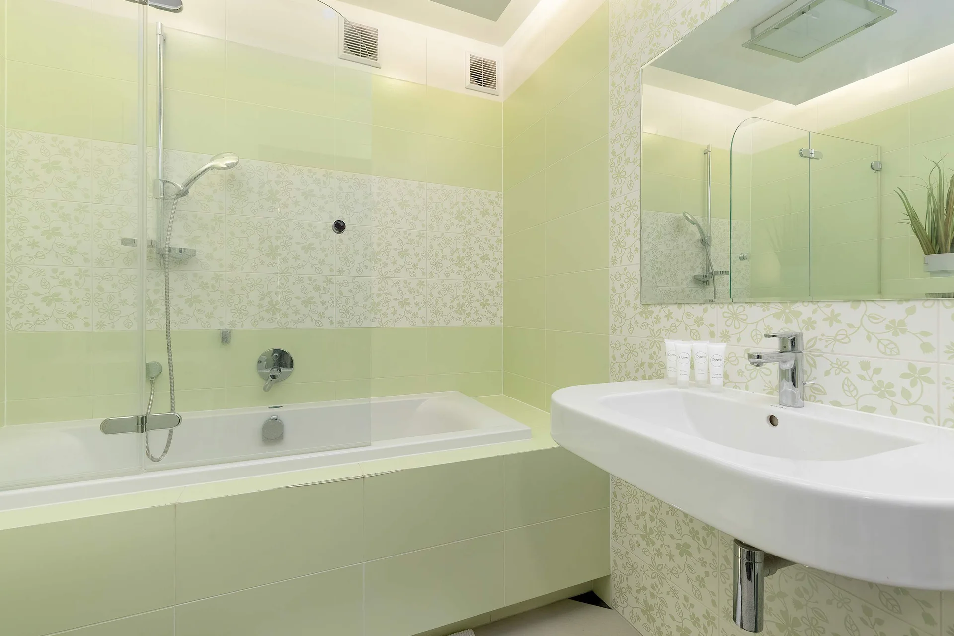 The bathroom's contemporary design includes fresh towels and a hairdryer.