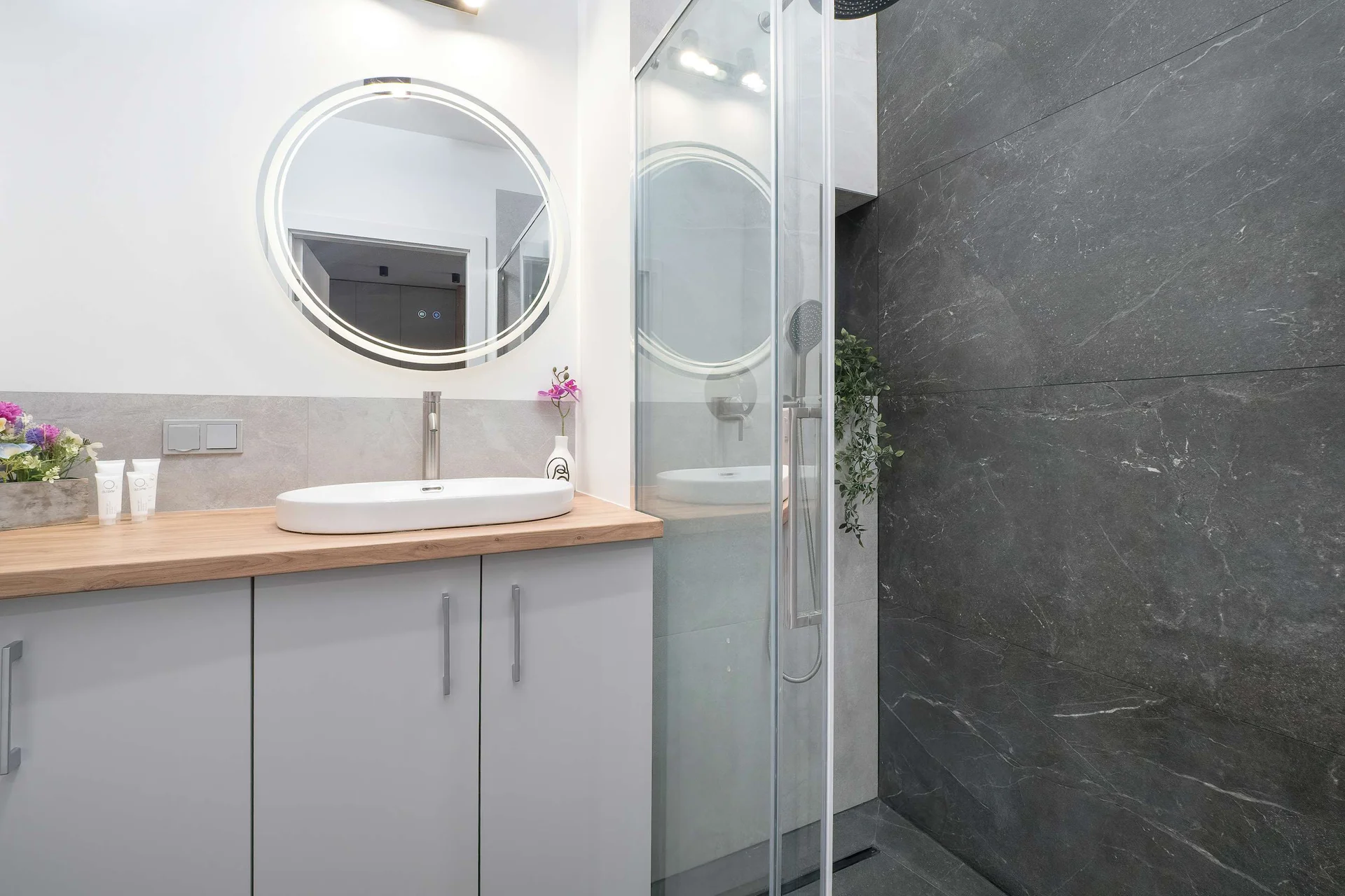 The bathroom's contemporary design includes fresh towels and a hairdryer.