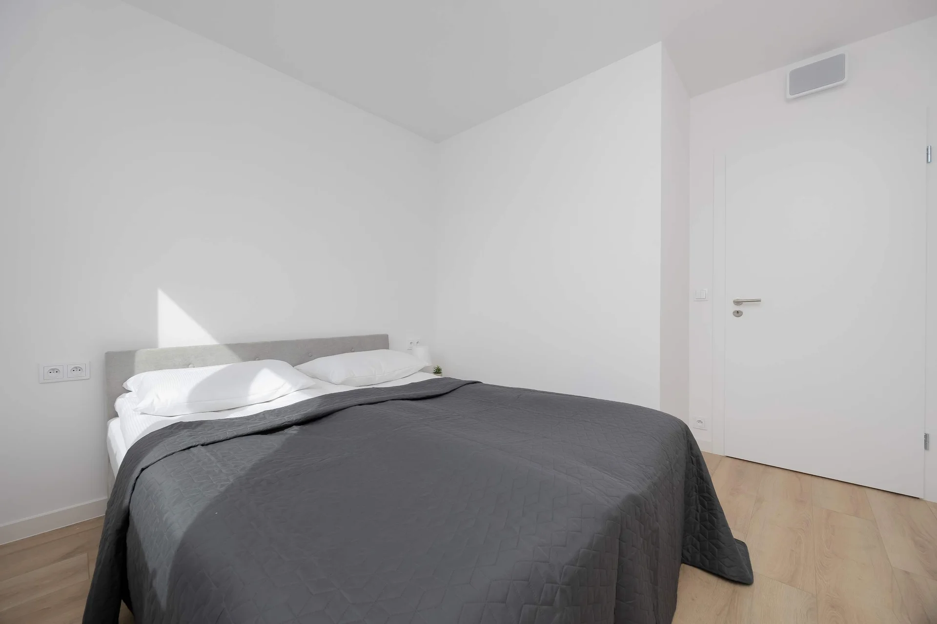 Bright bedroom with a double bed, wardrobe and large window overlooking the surroundings.