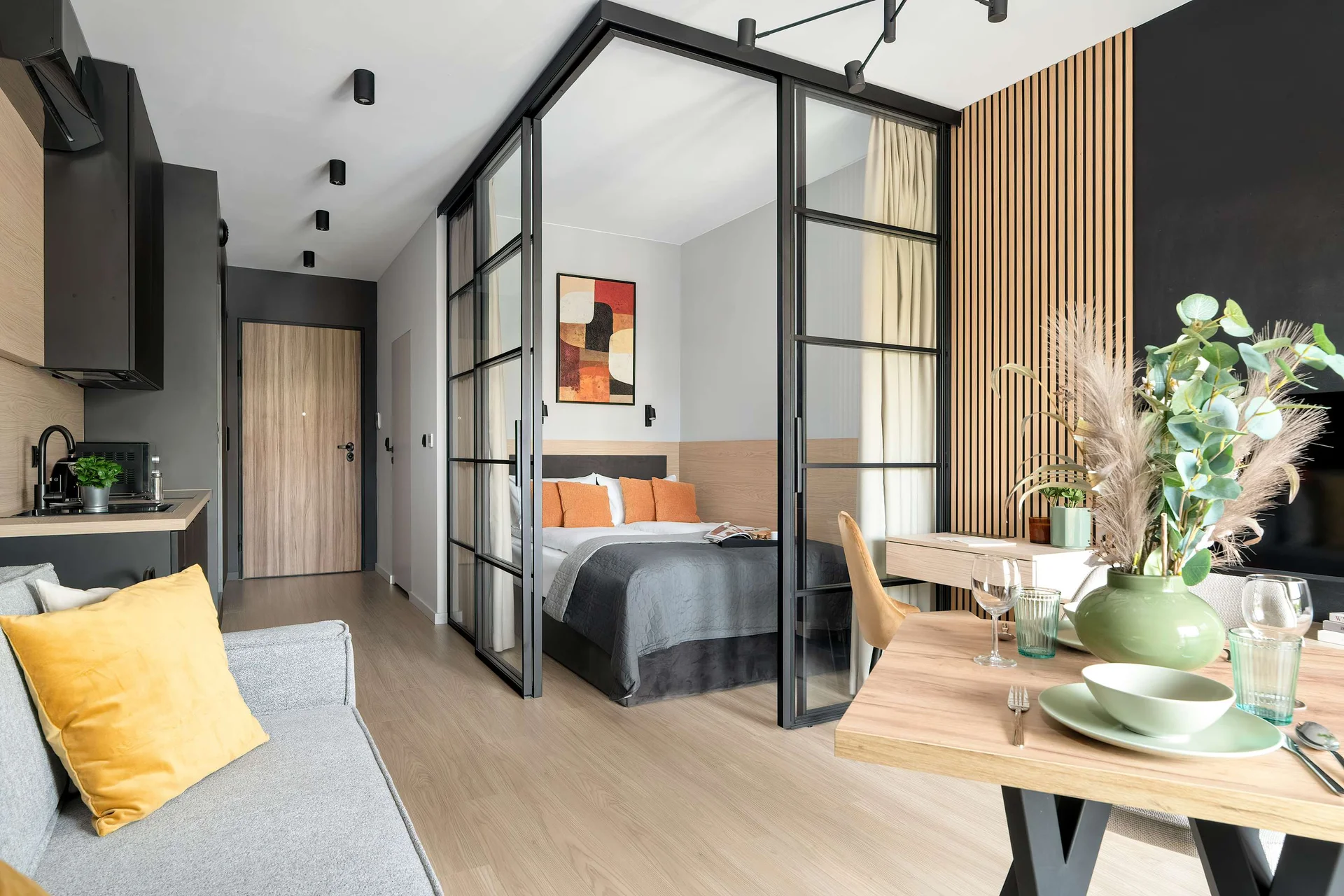 Elegant studio with a comfortable seating area, dining table, TV and large windows providing plenty of natural light.